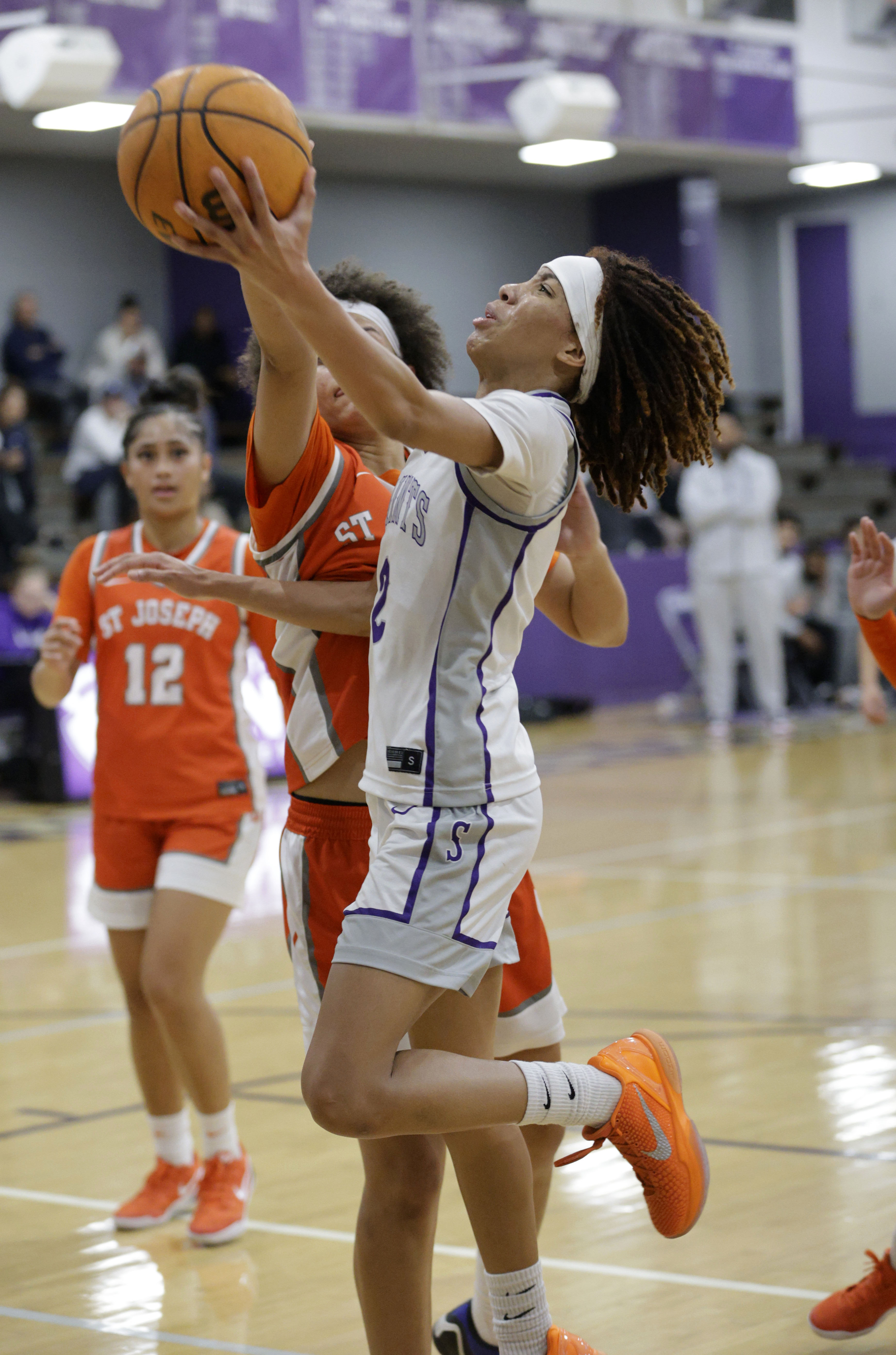 St. Anthonys Laila Hughs (2) shoots for two as they...