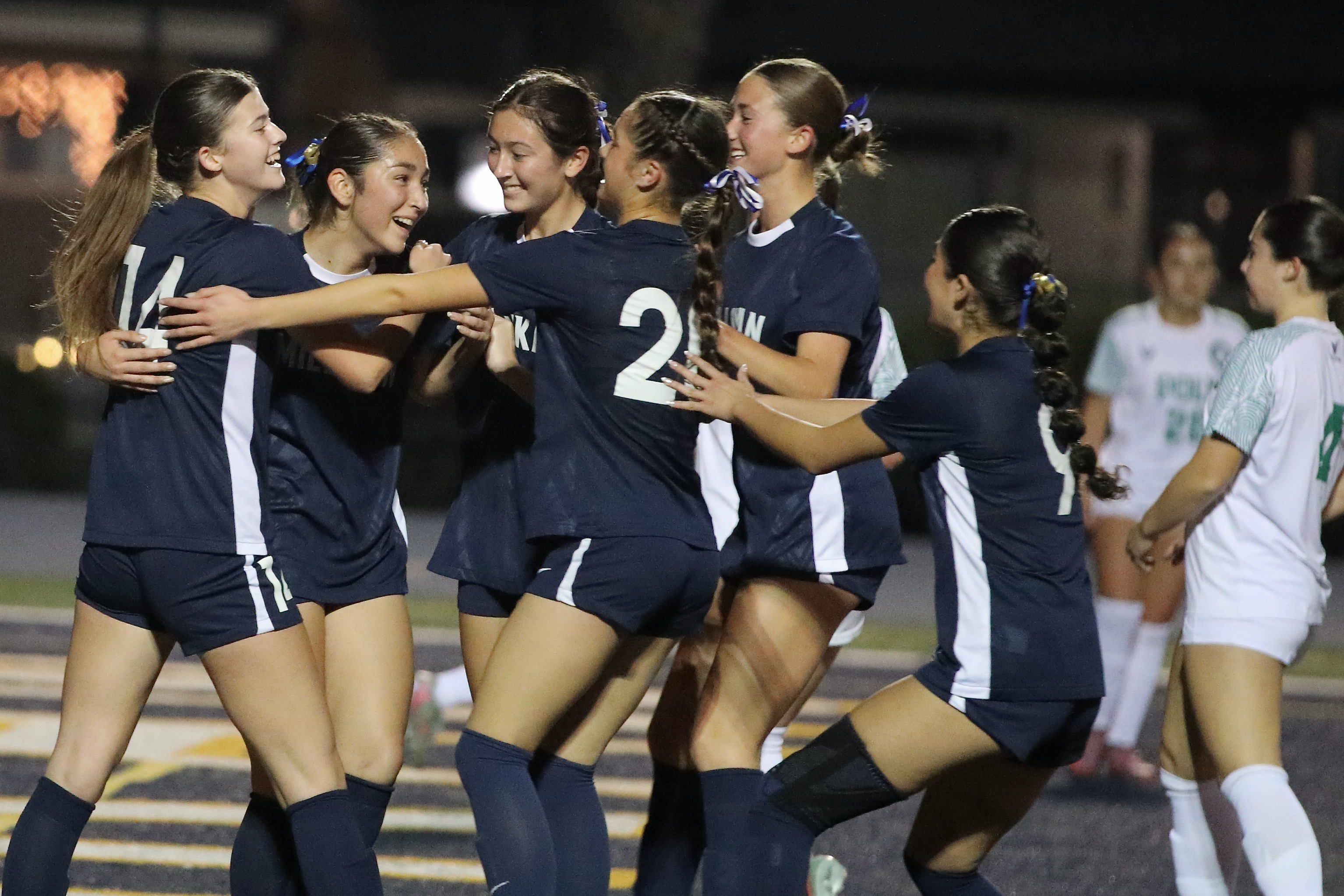 Millikan’s Jayla Cortes, second from left, is swarmed by teammates...
