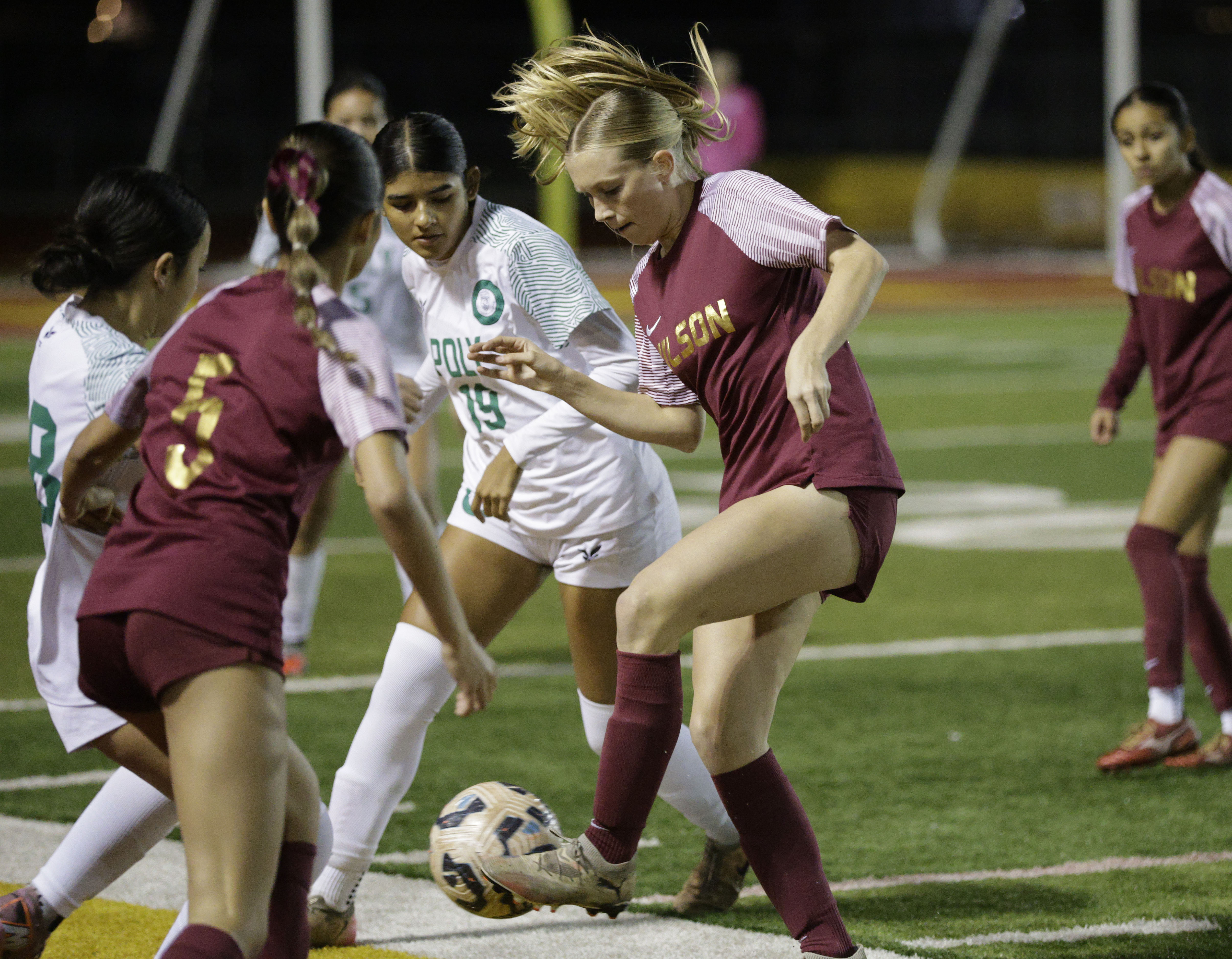 Wilson’s Ella George (11) tries to keep the ball from...