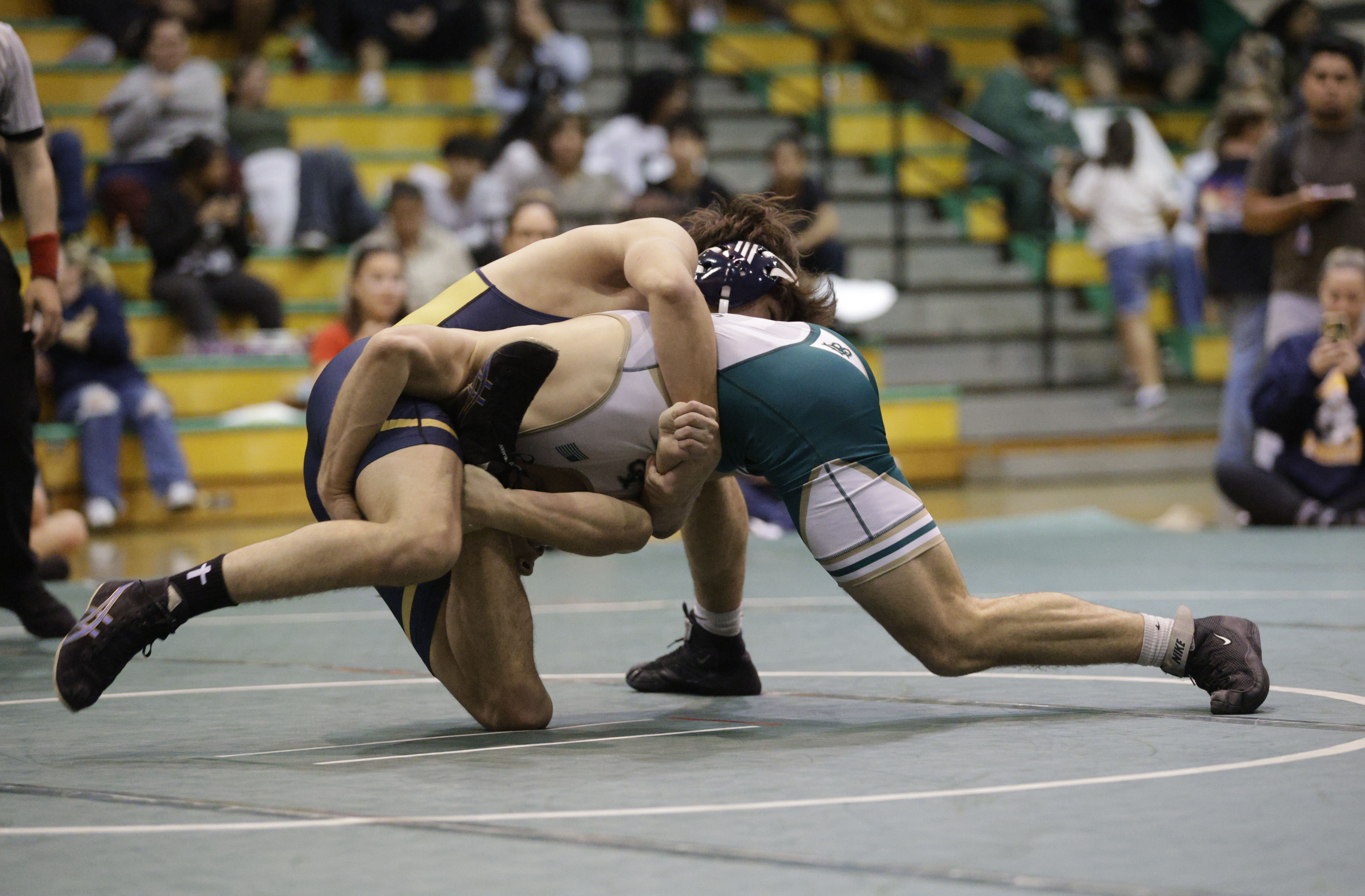 Millikan’s Chris Anguiano takes on Long Beach Poly’s Augustus Brown...