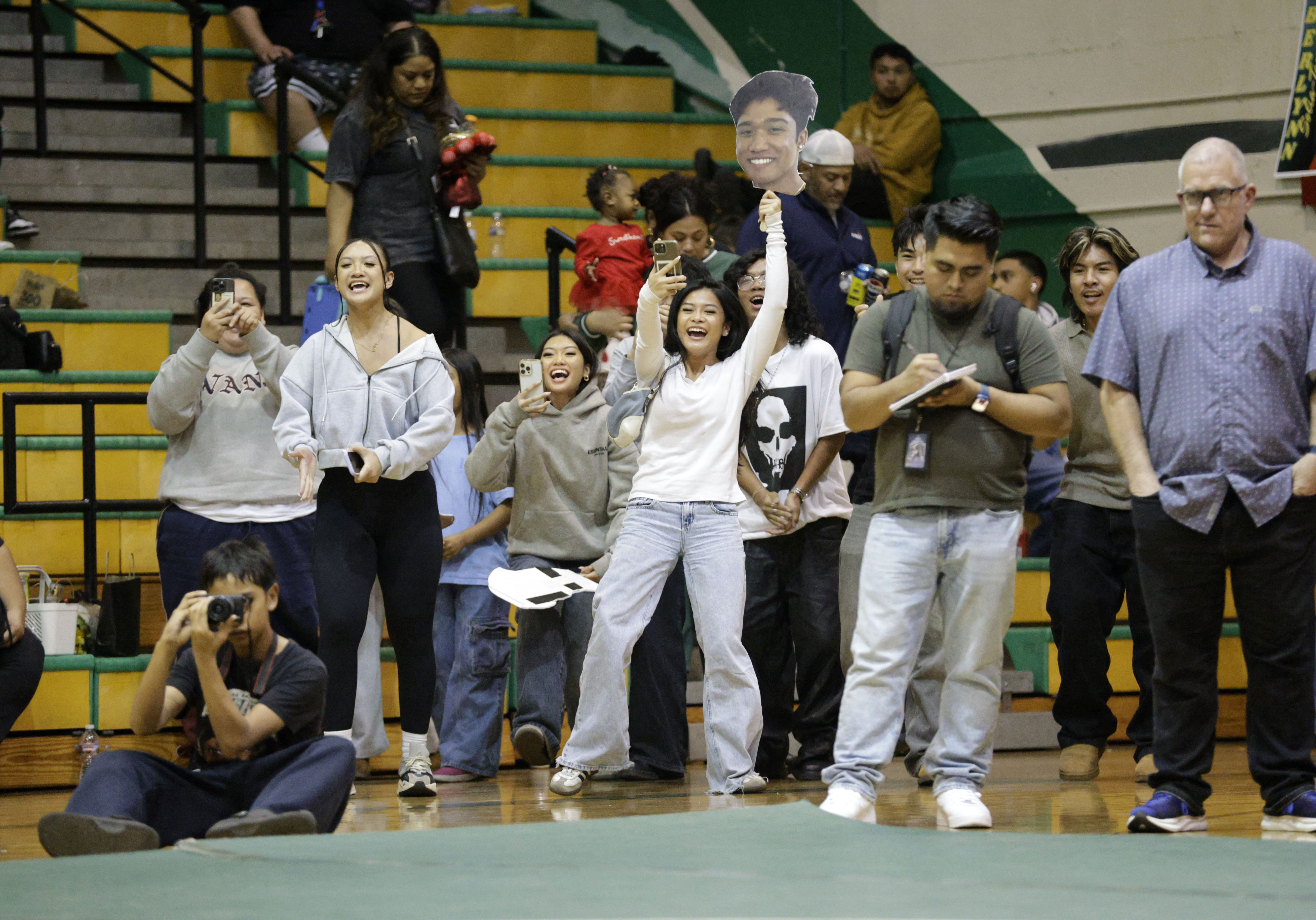 Long Beach Poly fans cheer on their wrestler in the...