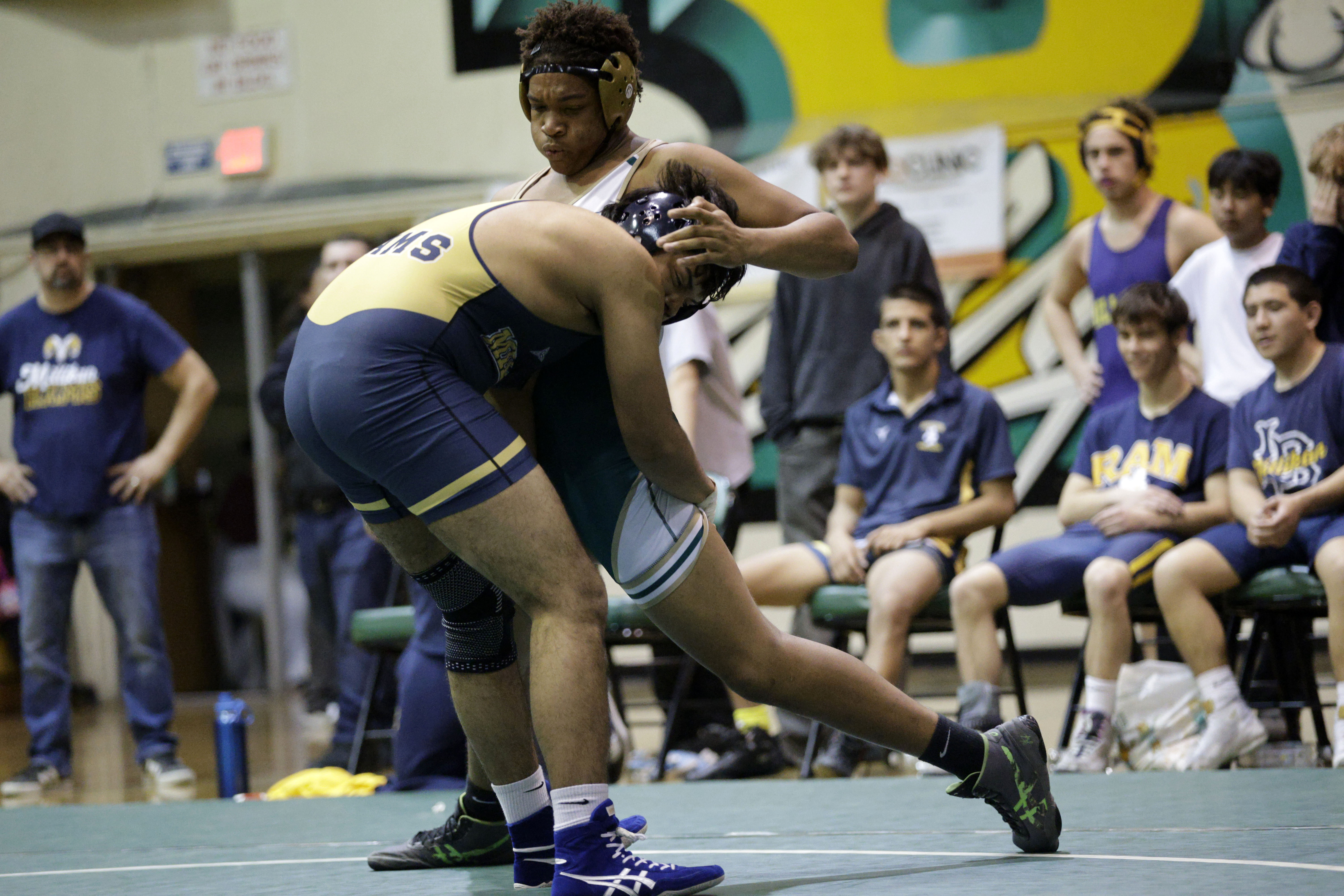 Millikan’s Daniel Escobedo takes on Long Beach Poly’s Kevin Bennett...
