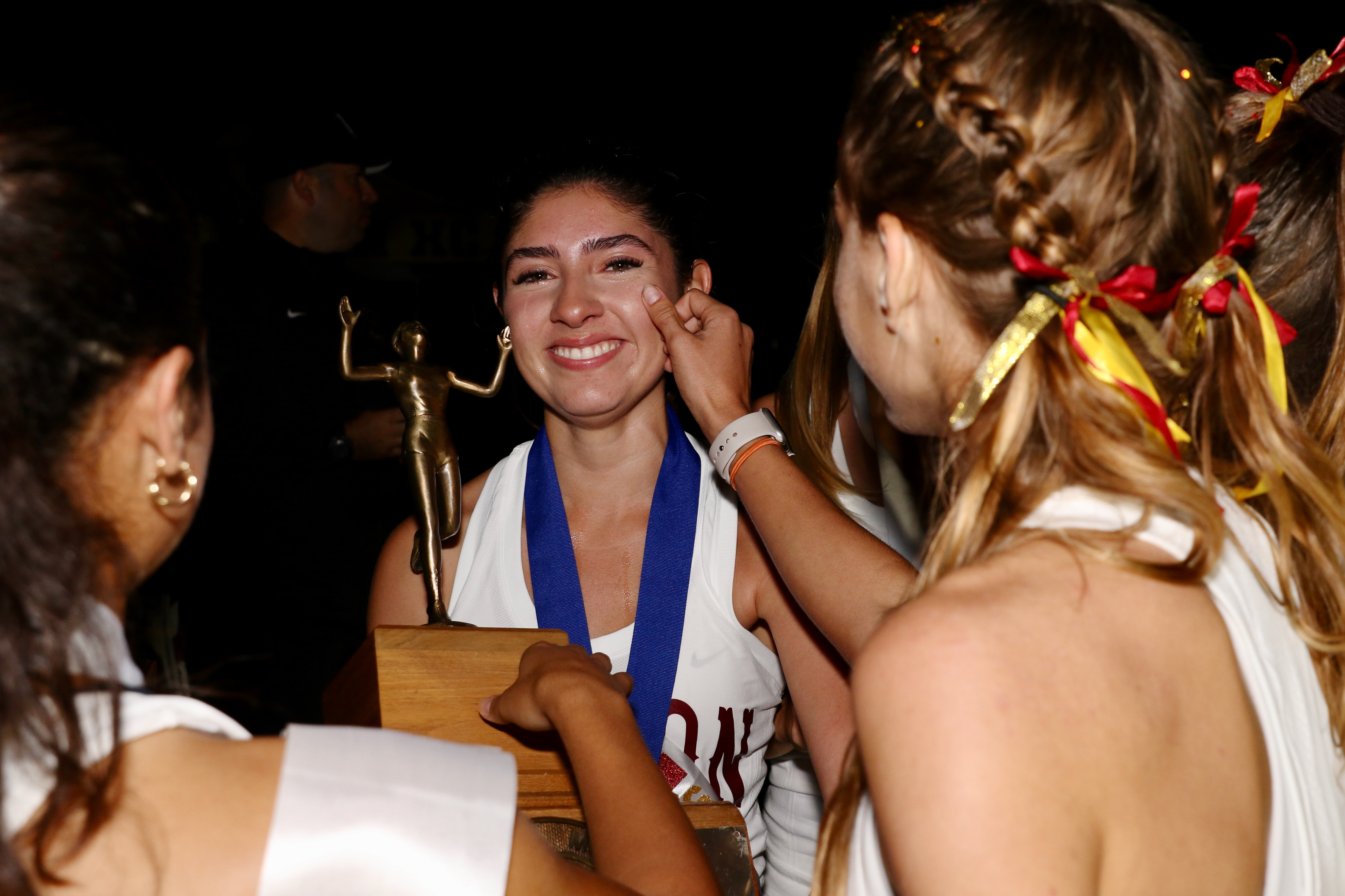 A teammate wipes a joyful tear off the cheek of...