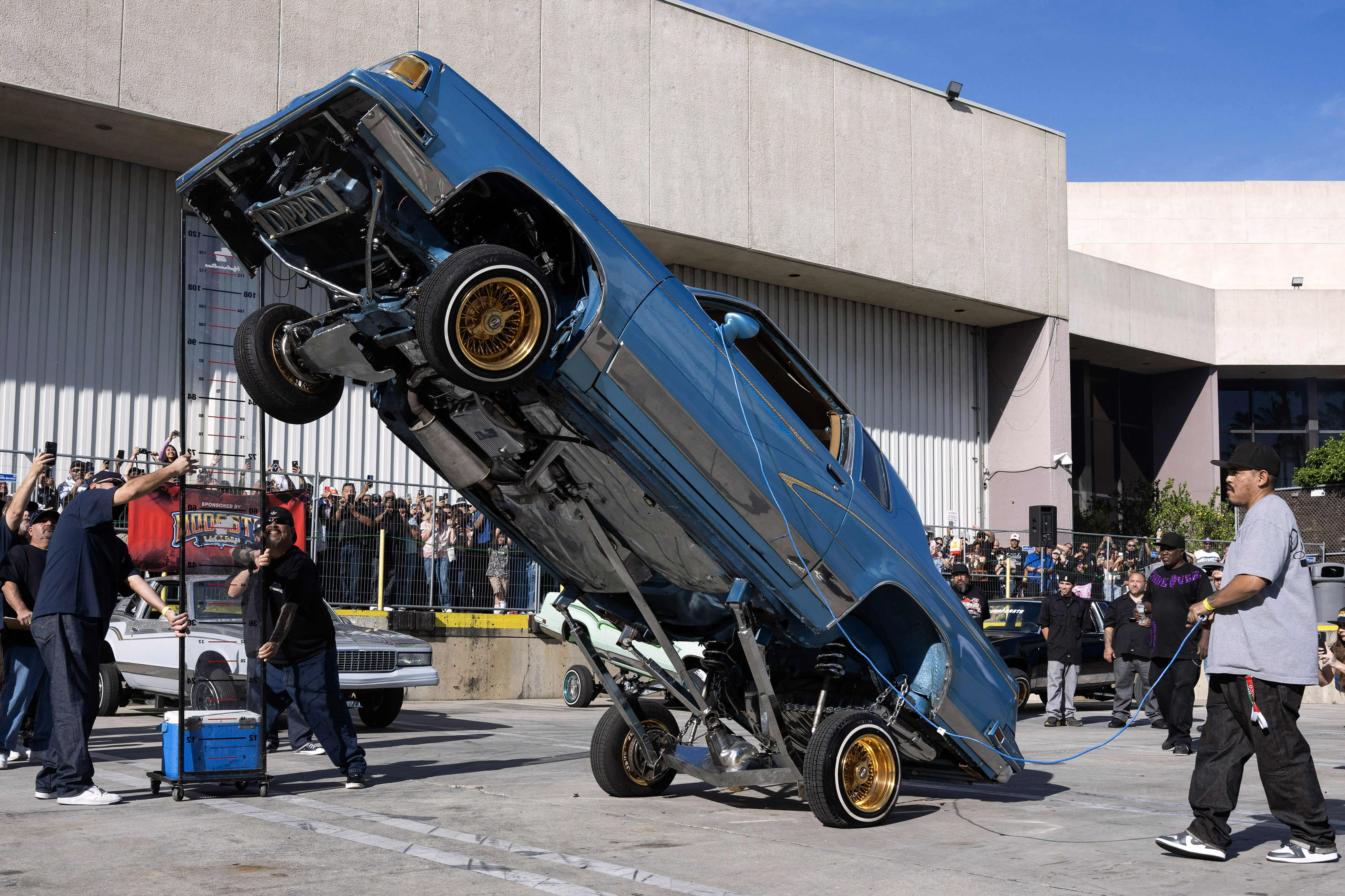 Julio Villanueva, right, competes with his modified 1988 Oldsmobile Cutlass...