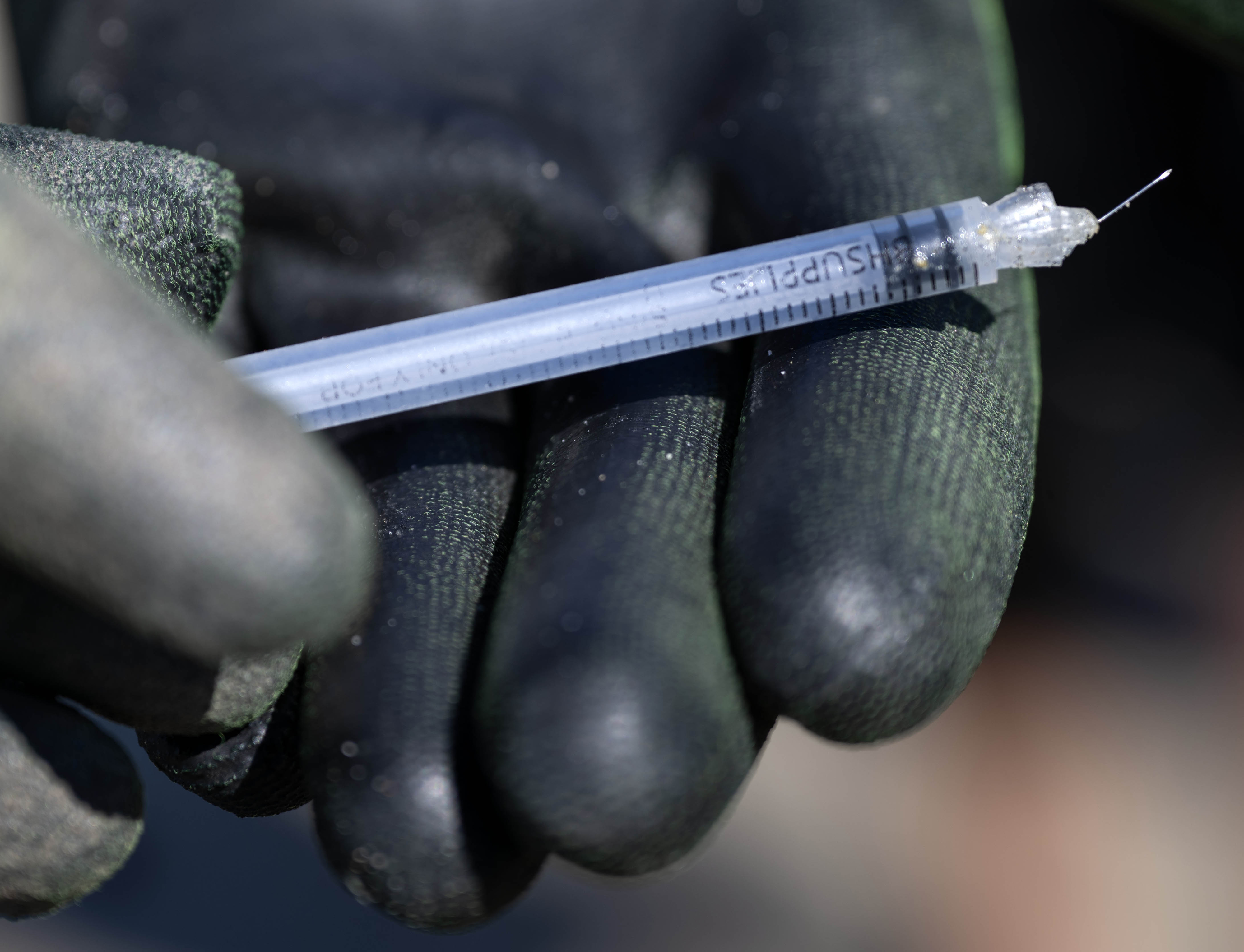 Tyion Robinson with Algalita, carefully handles a hypodermic needle that...