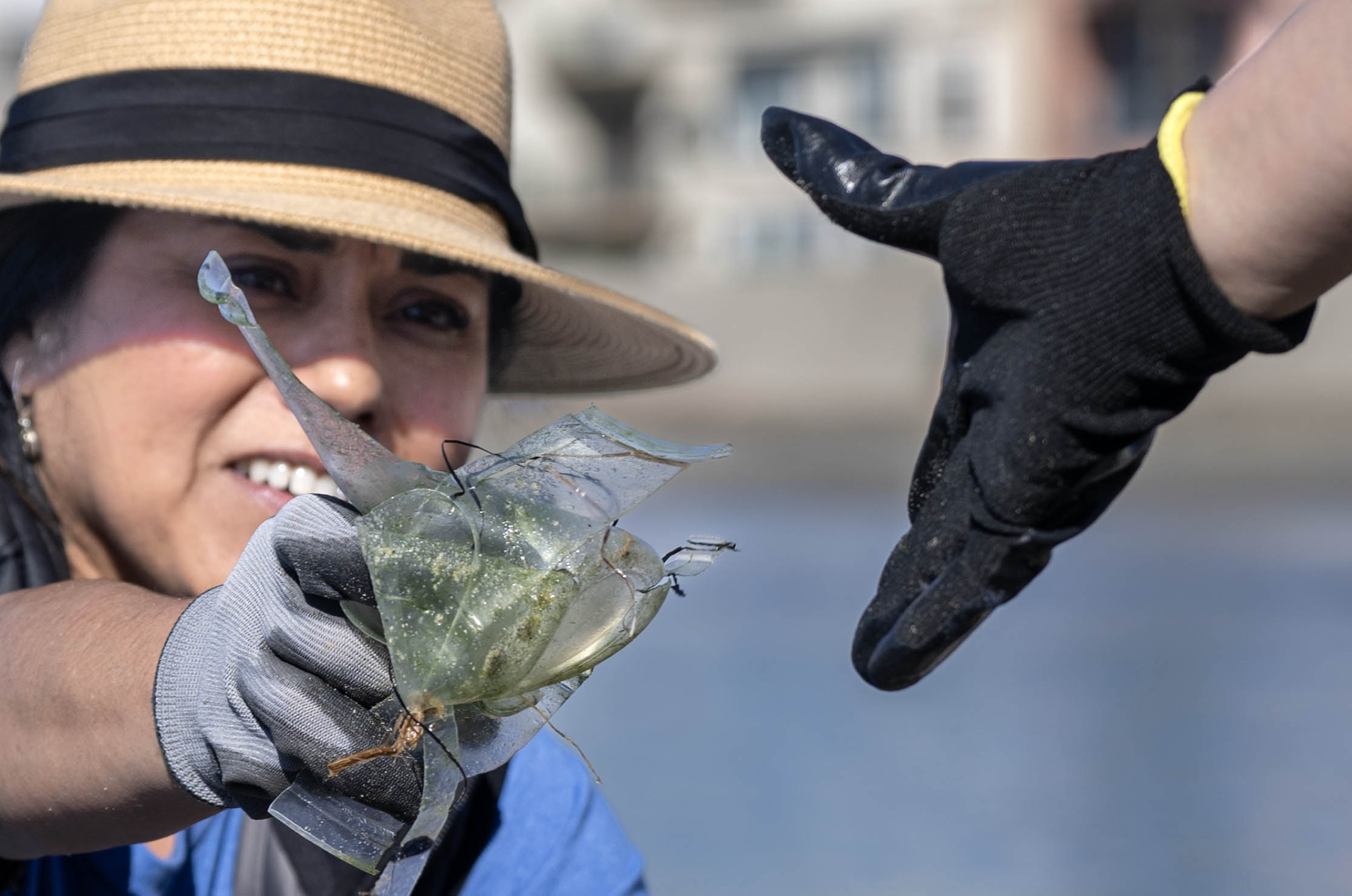 Charmaine Morales hands her sister, Helani Godinez, trash she picks...