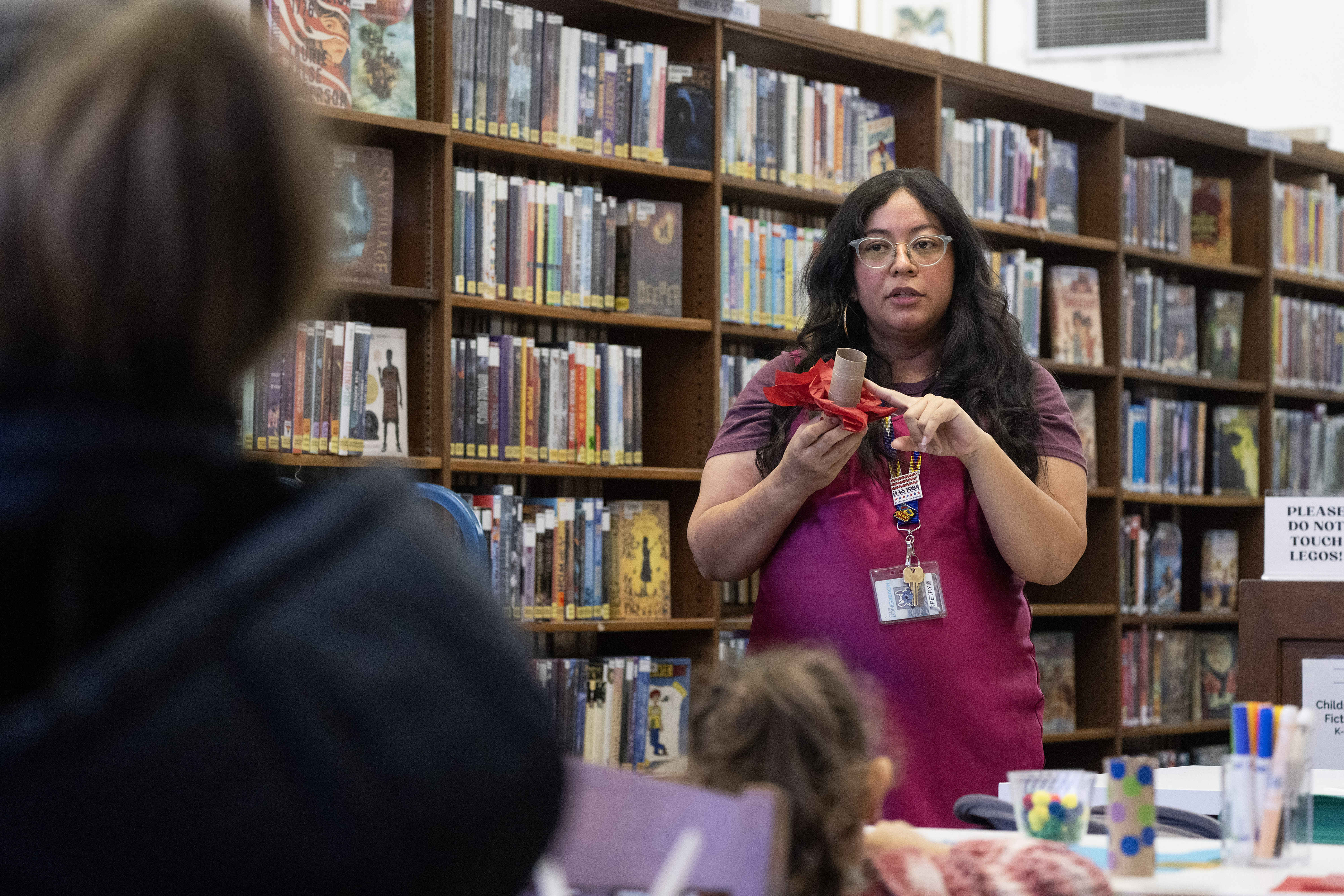 Senior Librarian Petry Saenz leads a crafting class during a...