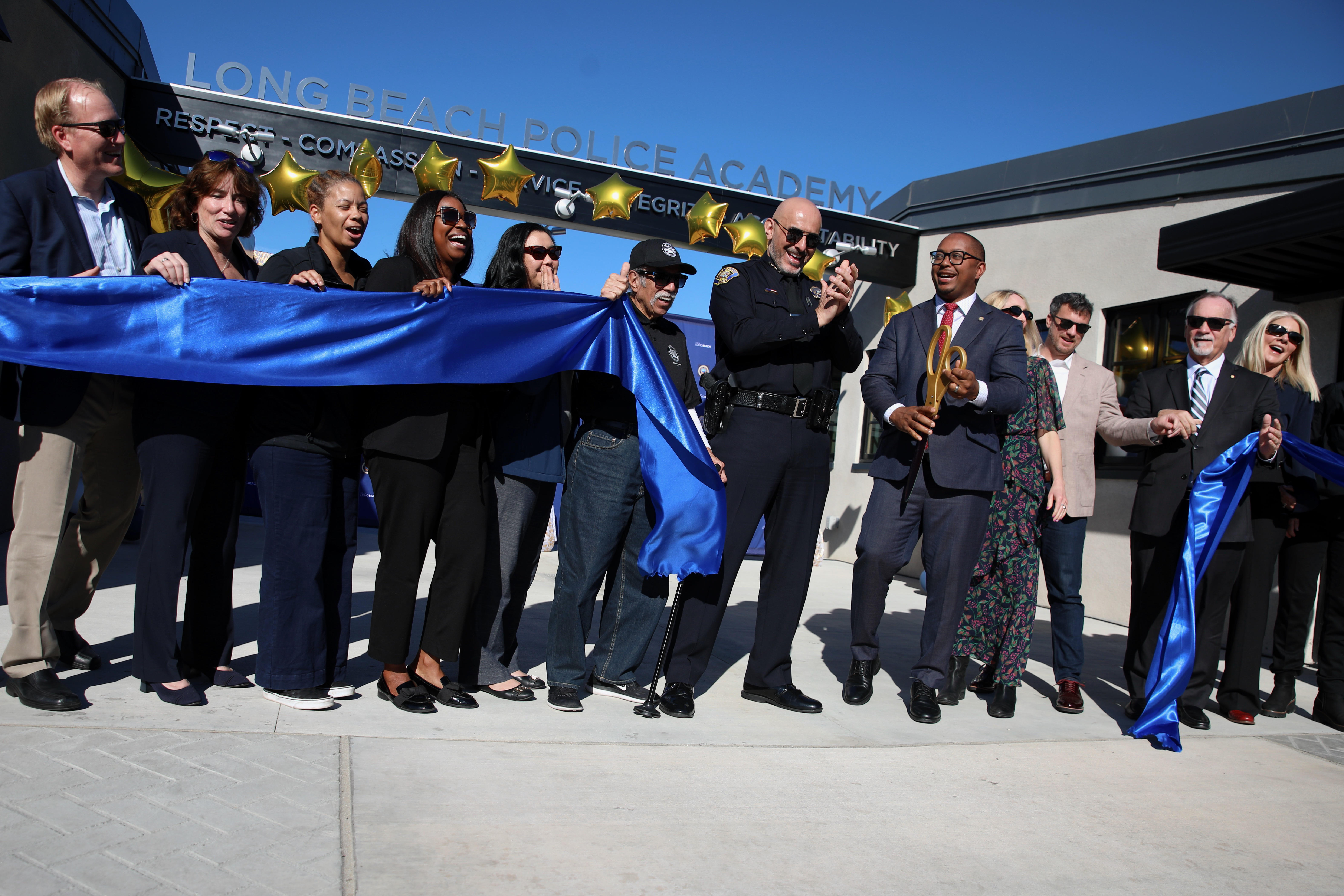 Surrounded by city leaders, Police Chief Wally Hebeish applauds after...