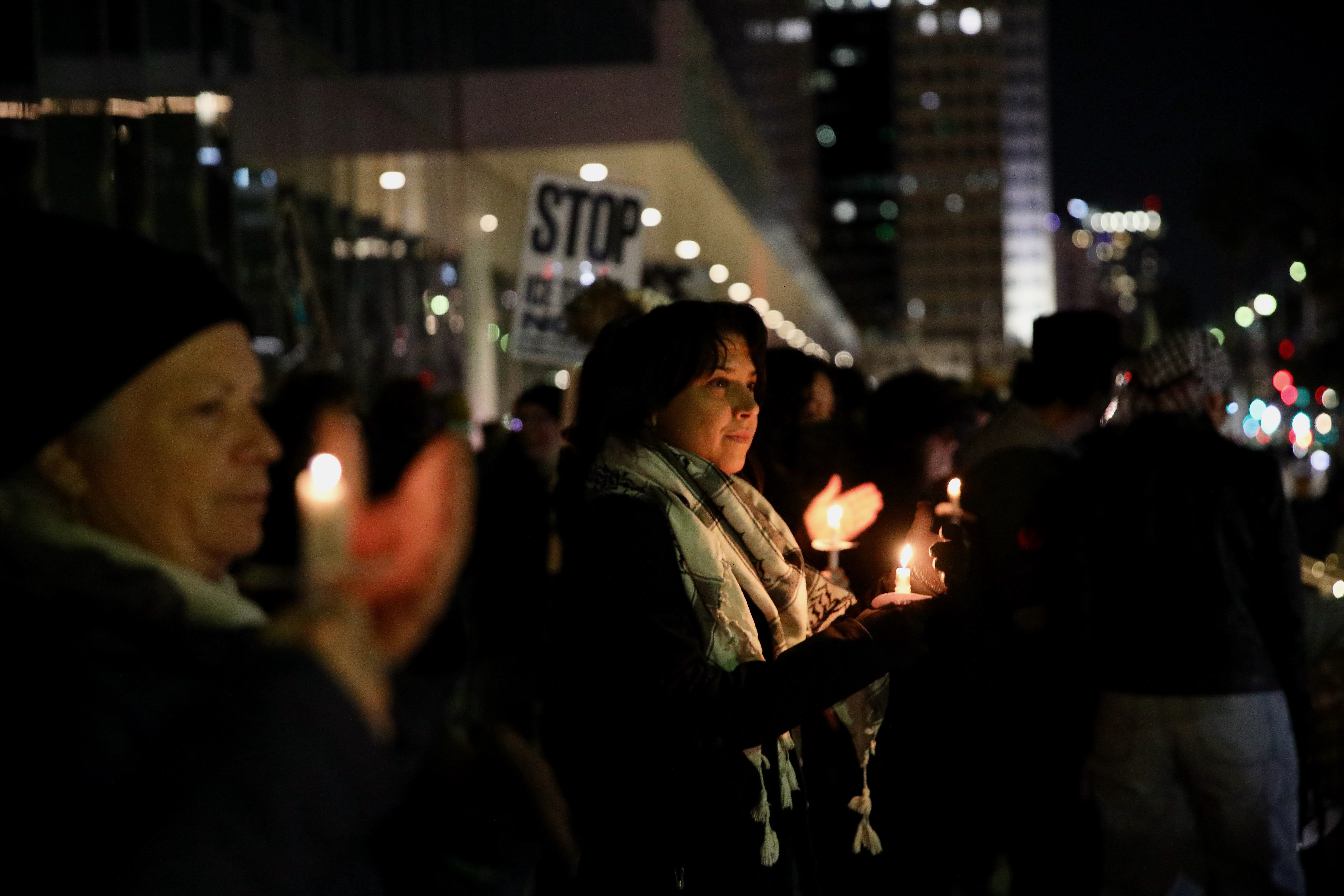Mourners hold candles near Long Beach City Hall on Thursday,...