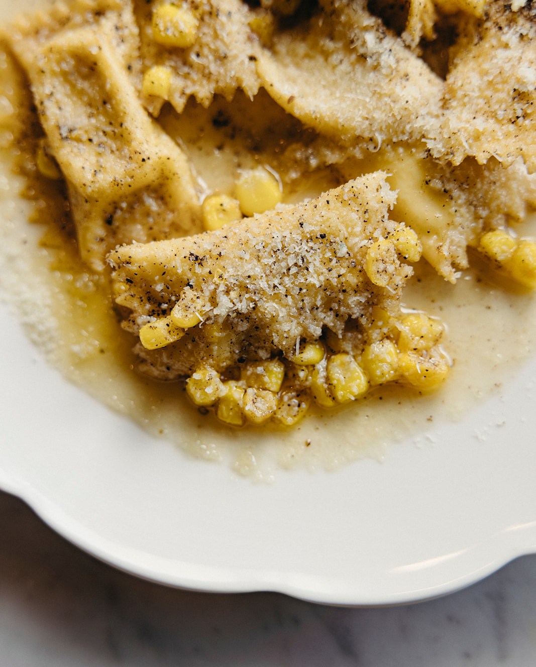 Close-up of agnolotti with corn and cheese in brown butter.