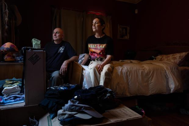Billy Malone, left, and his wife, Nina, pose for a photo in the bedroom of their home, which survived the Eaton Fire, Dec. 11, 2025, in Altadena, Calif. (AP Photo/Jae C. Hong)