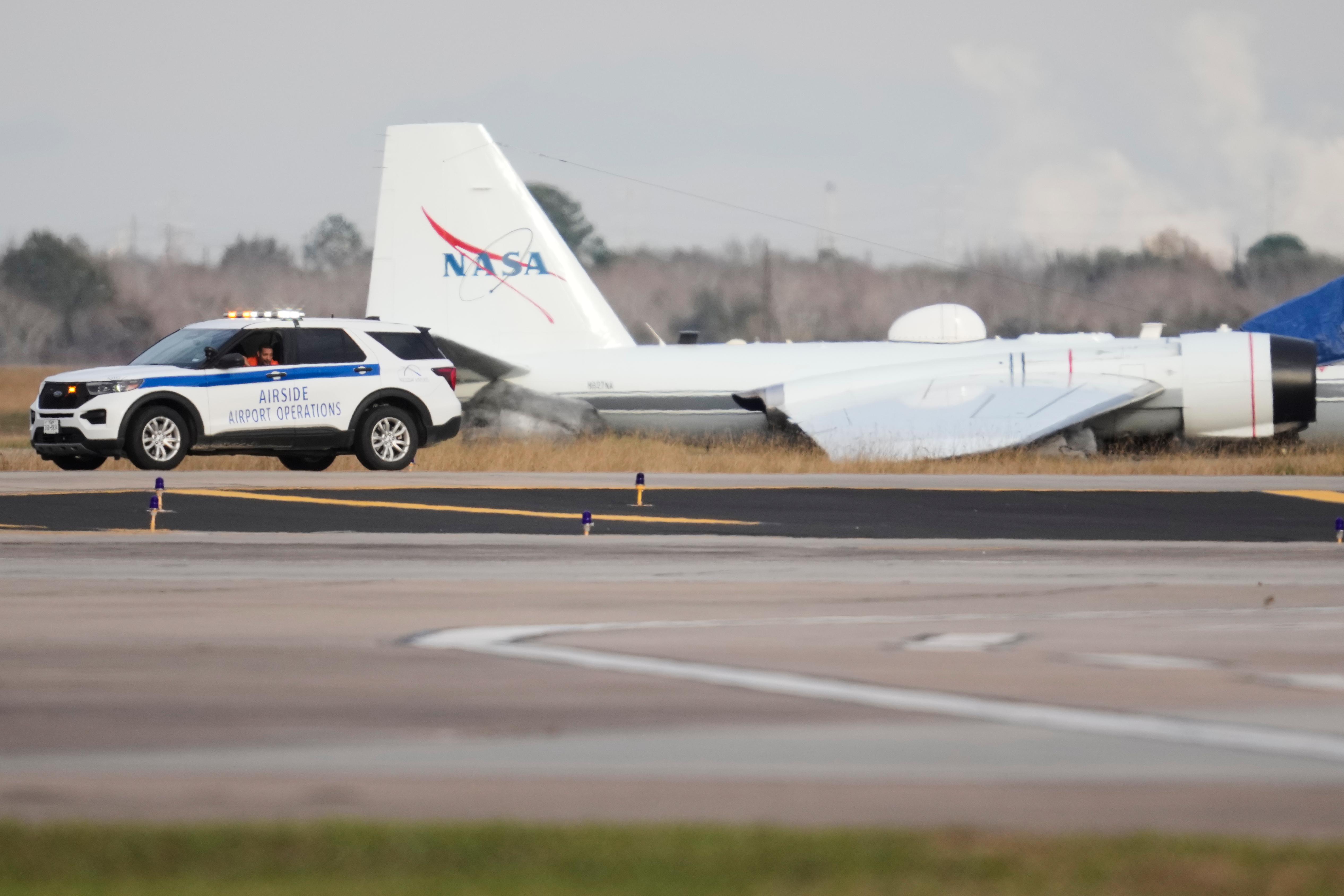 A NASA aircraft sits near a runway at Ellington Airport...