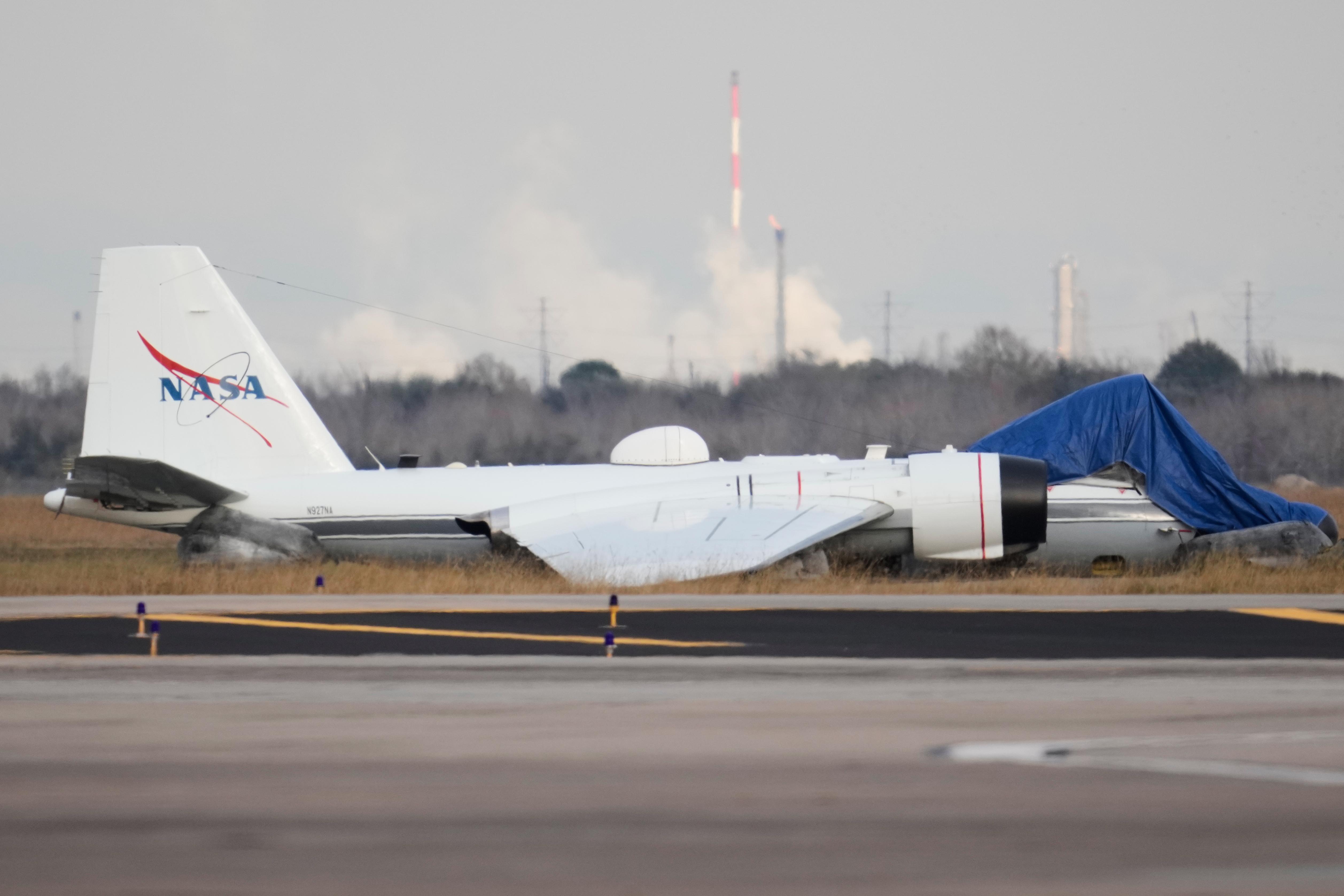 A NASA aircraft sits near a runway at Ellington Airport...