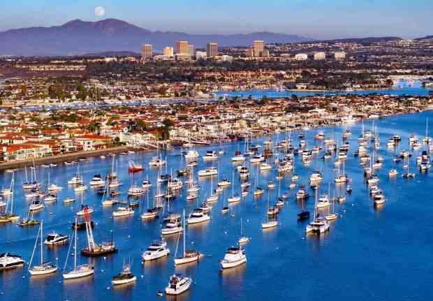 The moon rises over Saddleback, Santiago and Modjeska peaks, as boats fill Newport Harbor. In the 1930s, dredging work commenced, and artificial islands such as Balboa Island and Lido Isle were created. With approximately 9,000 boats, Newport Harbor is one of the largest recreational boat harbors on the West Coast. (Photo by Jeff Gritchen, Orange County Register/SCNG)