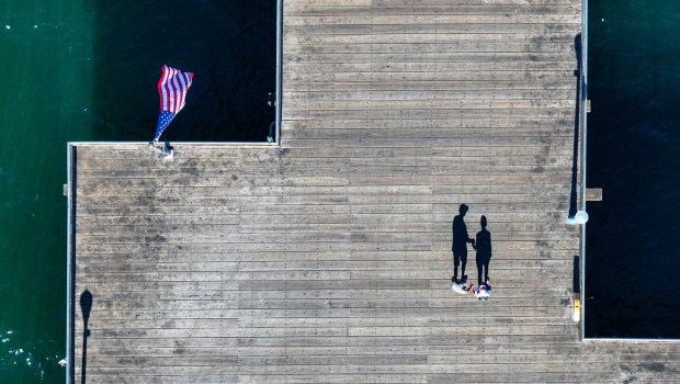 Shadows are cast on the pier as a U.S. flag flutters in the wind in Seal Beach in October. (Photo by Jeff Gritchen, Orange County Register/SCNG)