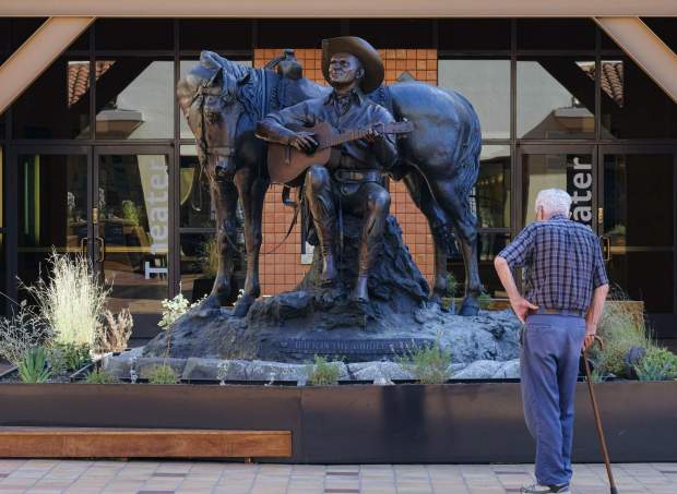 A visitor stands at a statue of Gene Autry at the entrance to the Autry Museum of the American West in Los Angeles in 2016. (AP Photo/Richard Vogel)