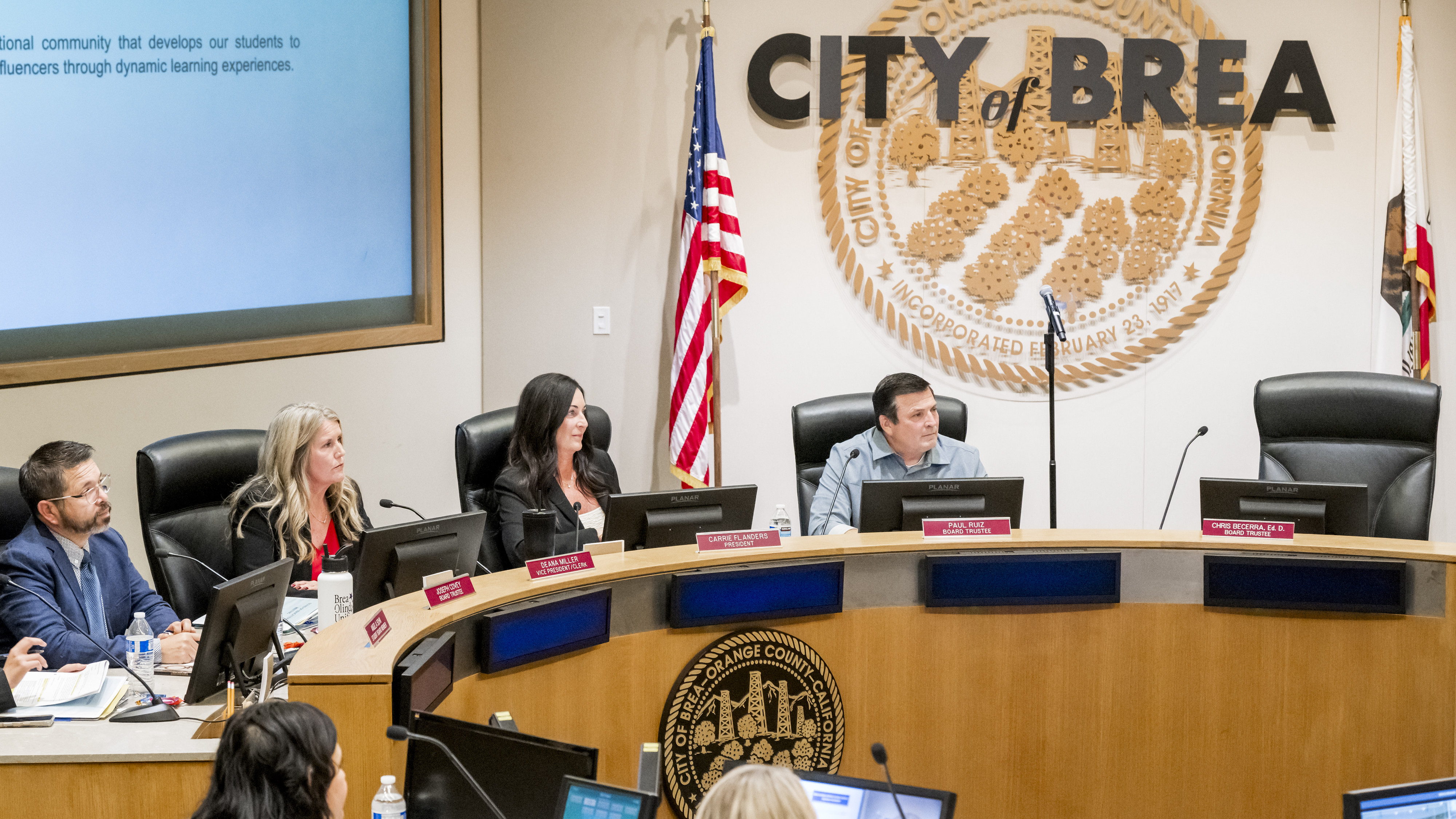 The empty chair of Trustee Christopher Becerra, right, stands out...