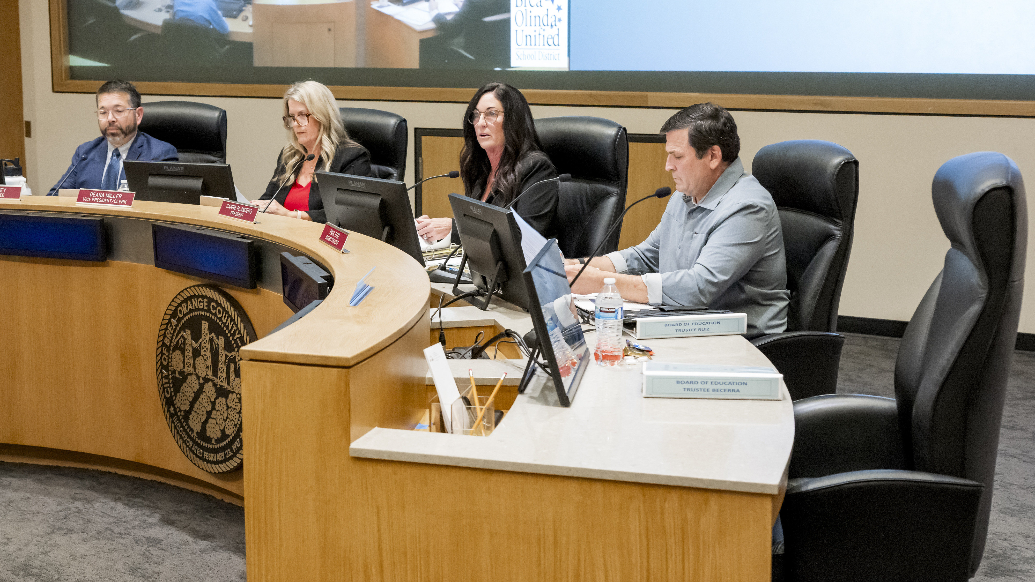 The empty chair of Trustee Christopher Becerra, right, stands out...
