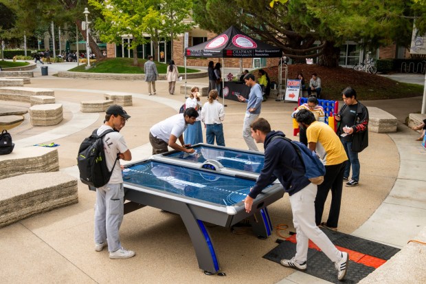 Chapman students play air hockey during a Voter Registration Bash in the Attallah Piazza in Orange on Thursday, Oct. 17, 2024. The event is sponsored by the Argyros Forum Student Union and Student Government Association. (Photo by Leonard Ortiz, Orange County Register/SCNG)