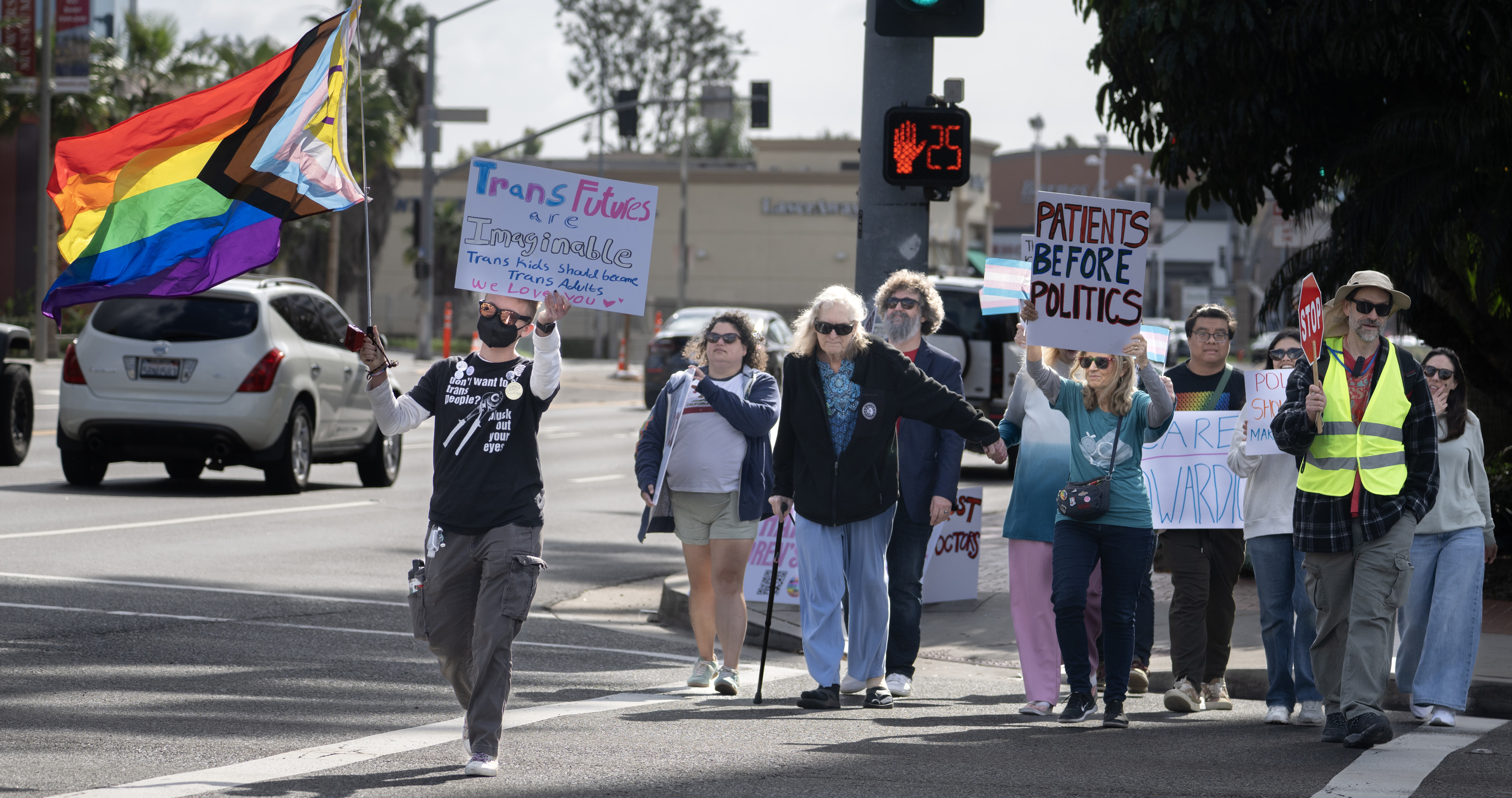 Cass Malcor, left, carries the Progress Pride flag during the...