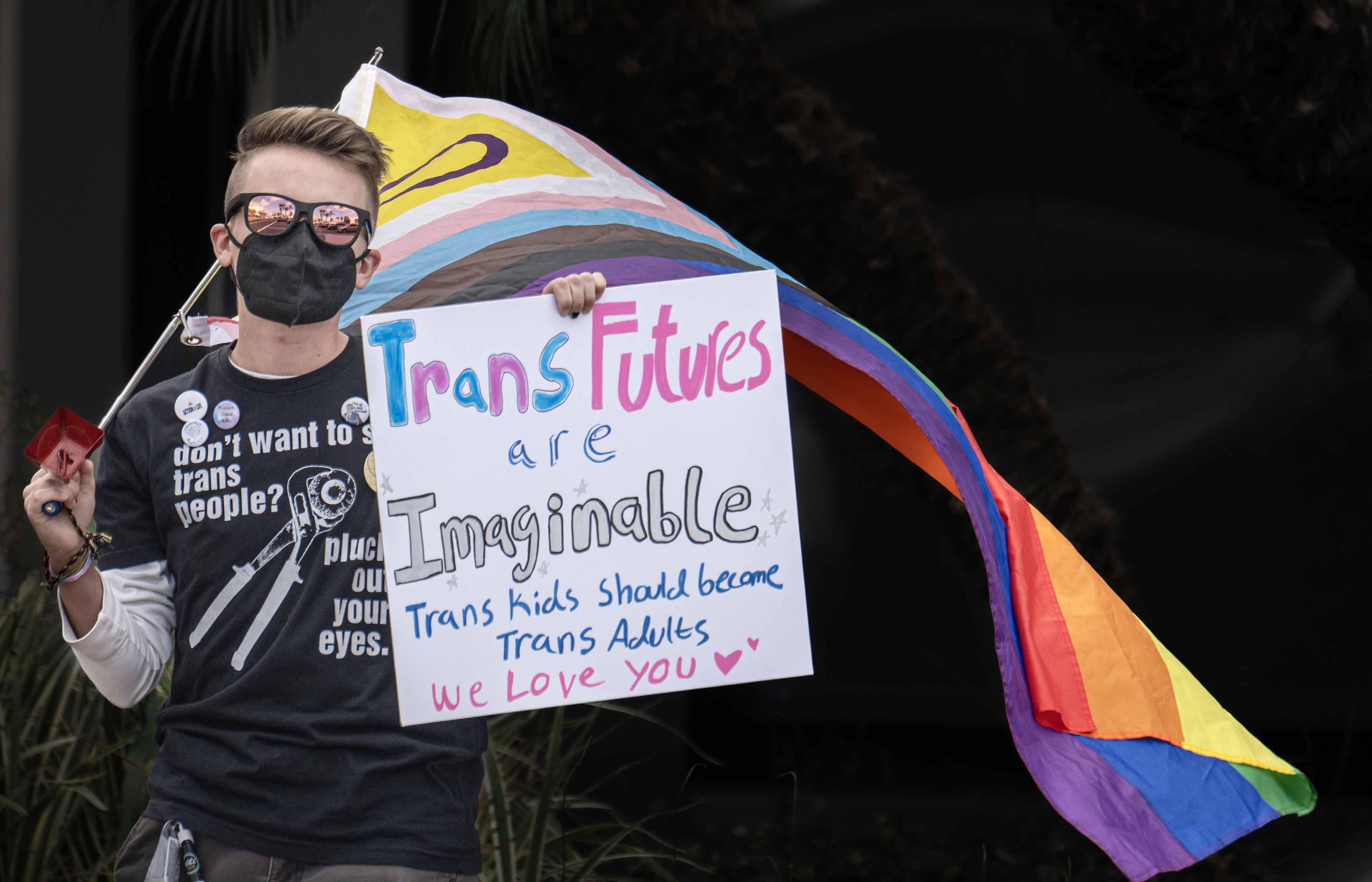 Cass Malcor holds the Progress Pride flag during the “Patients...