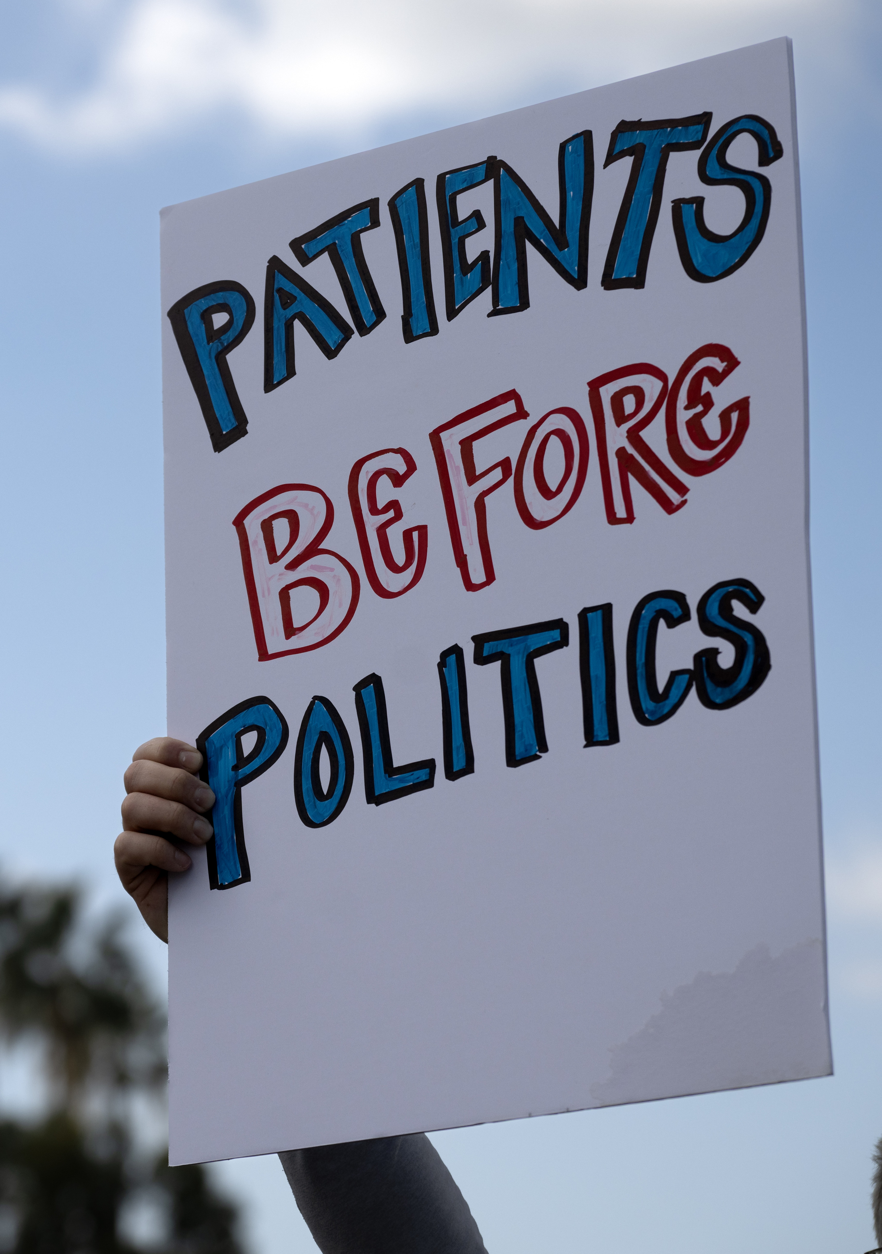 Several dozen people take part in the “Patients Before Politics”...