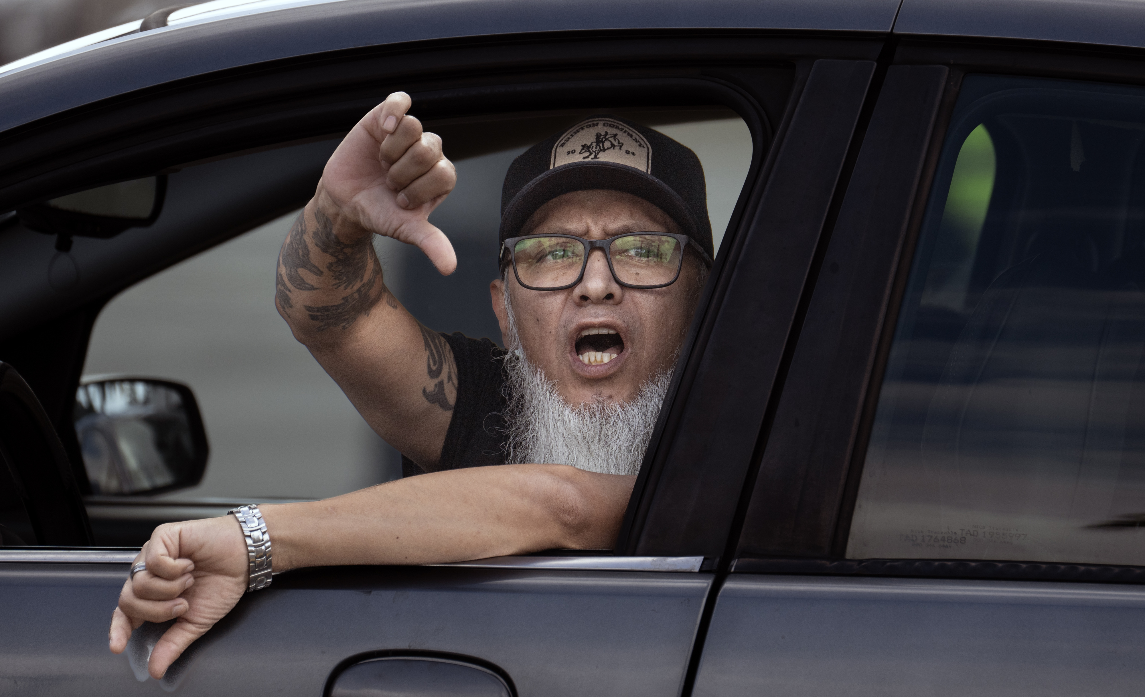 An angry motorist reacts to a group of protesters in...