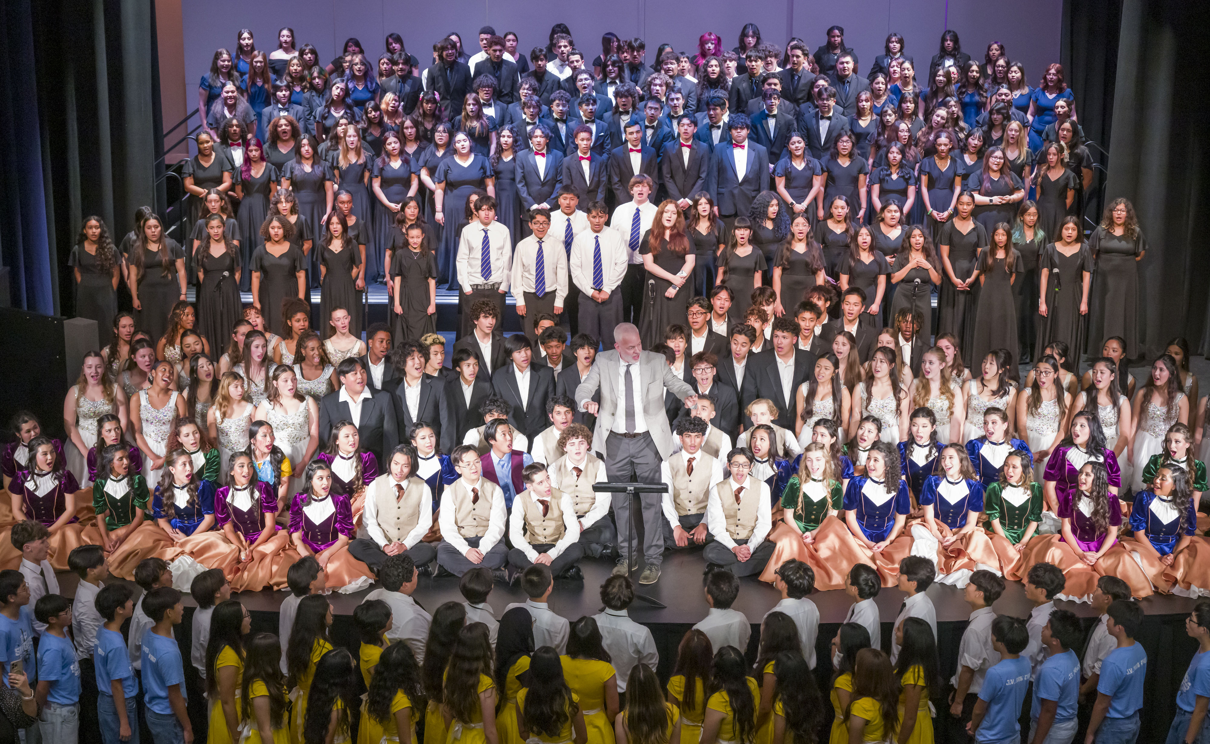 The combined AUHSD Choirs gather on and around the stage...