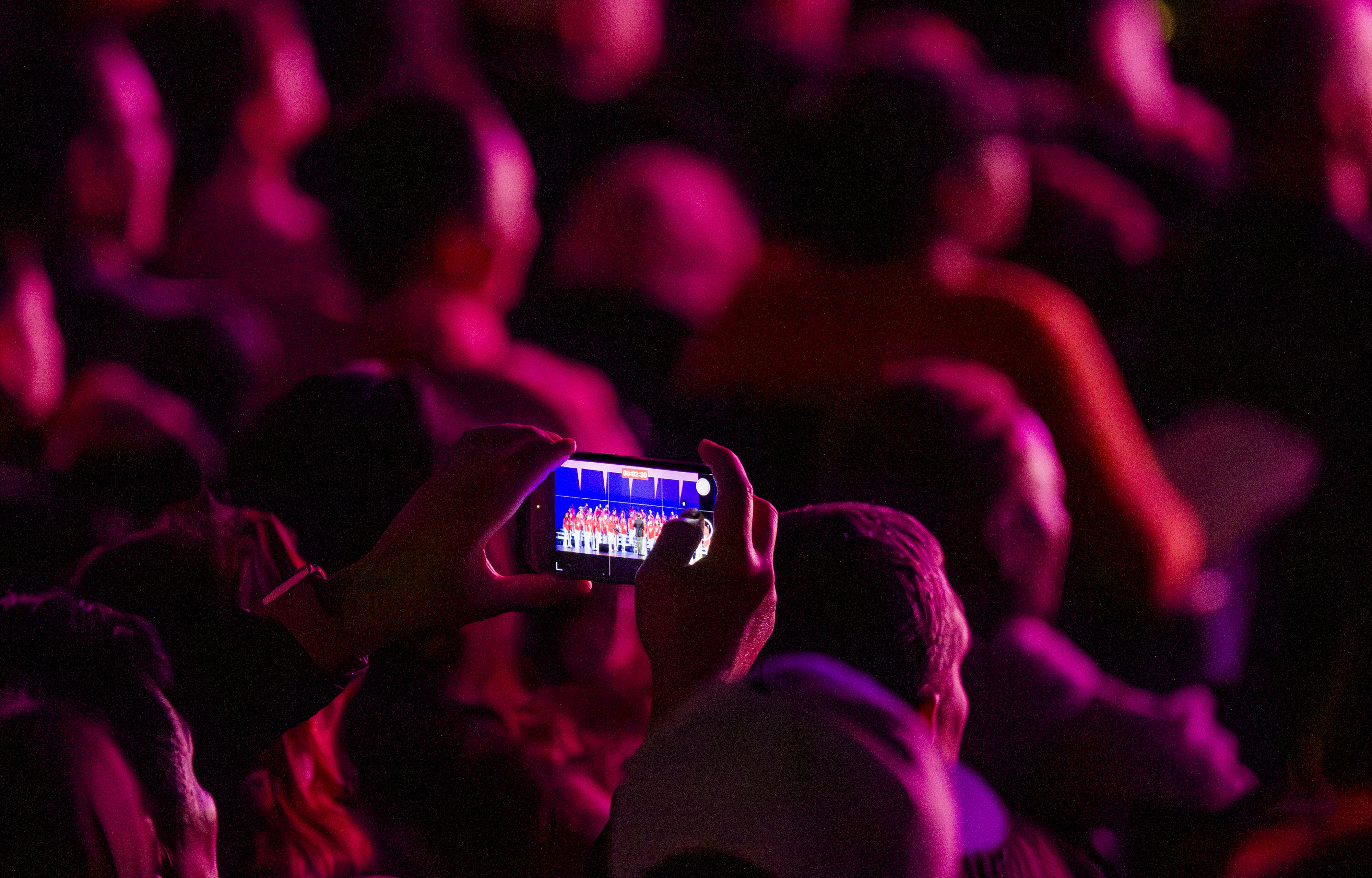 A parent in the auditorium records the Walker Junior High...