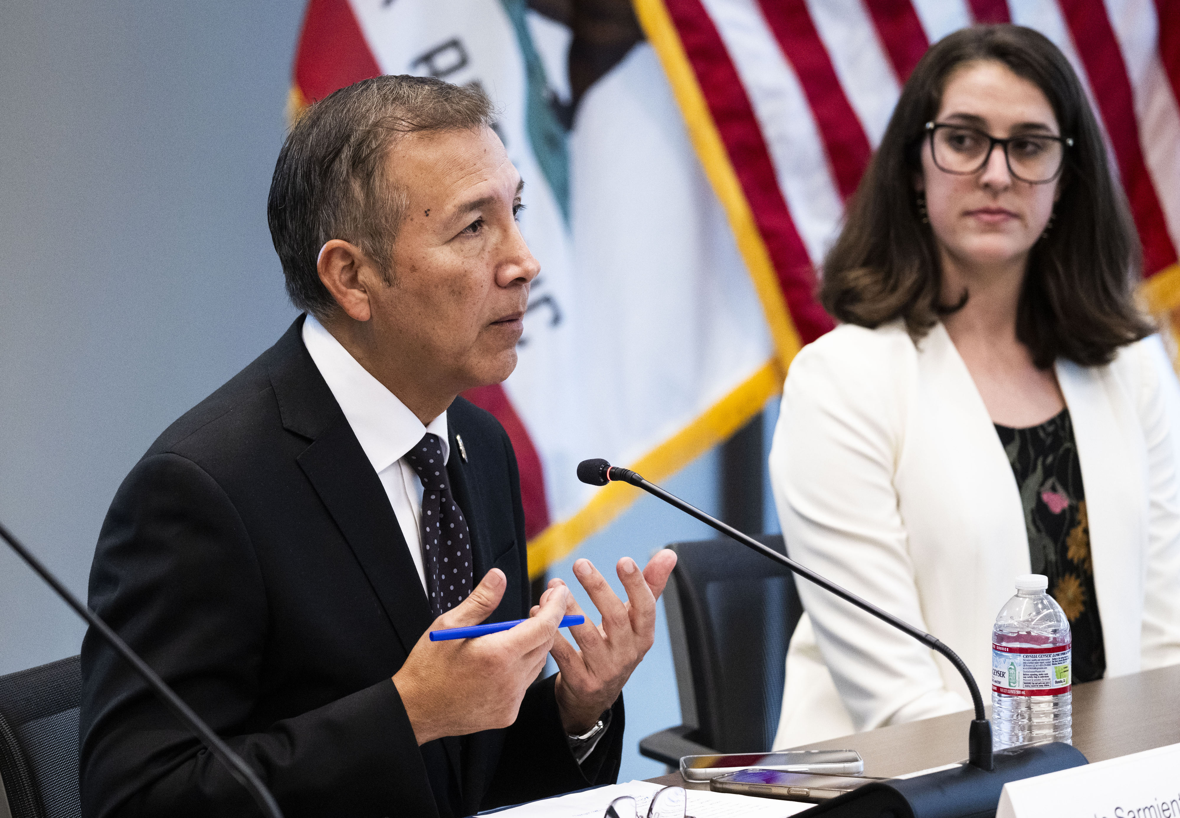 OC Supervisor Vicente Sarmiento speaks as Raiven Greenberg from the...