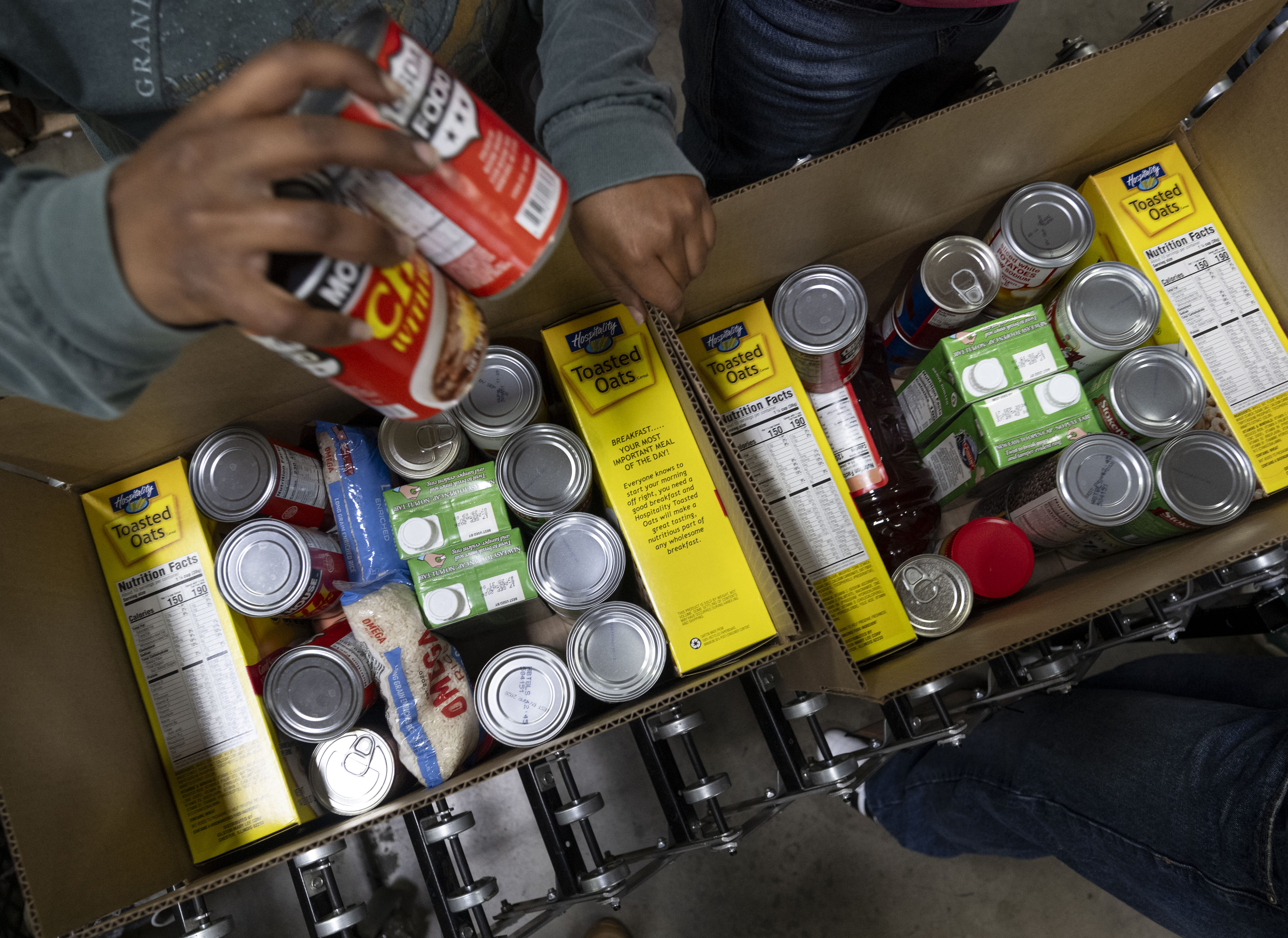 Volunteers pack boxes of shelf-stable food during the Martin Luther...