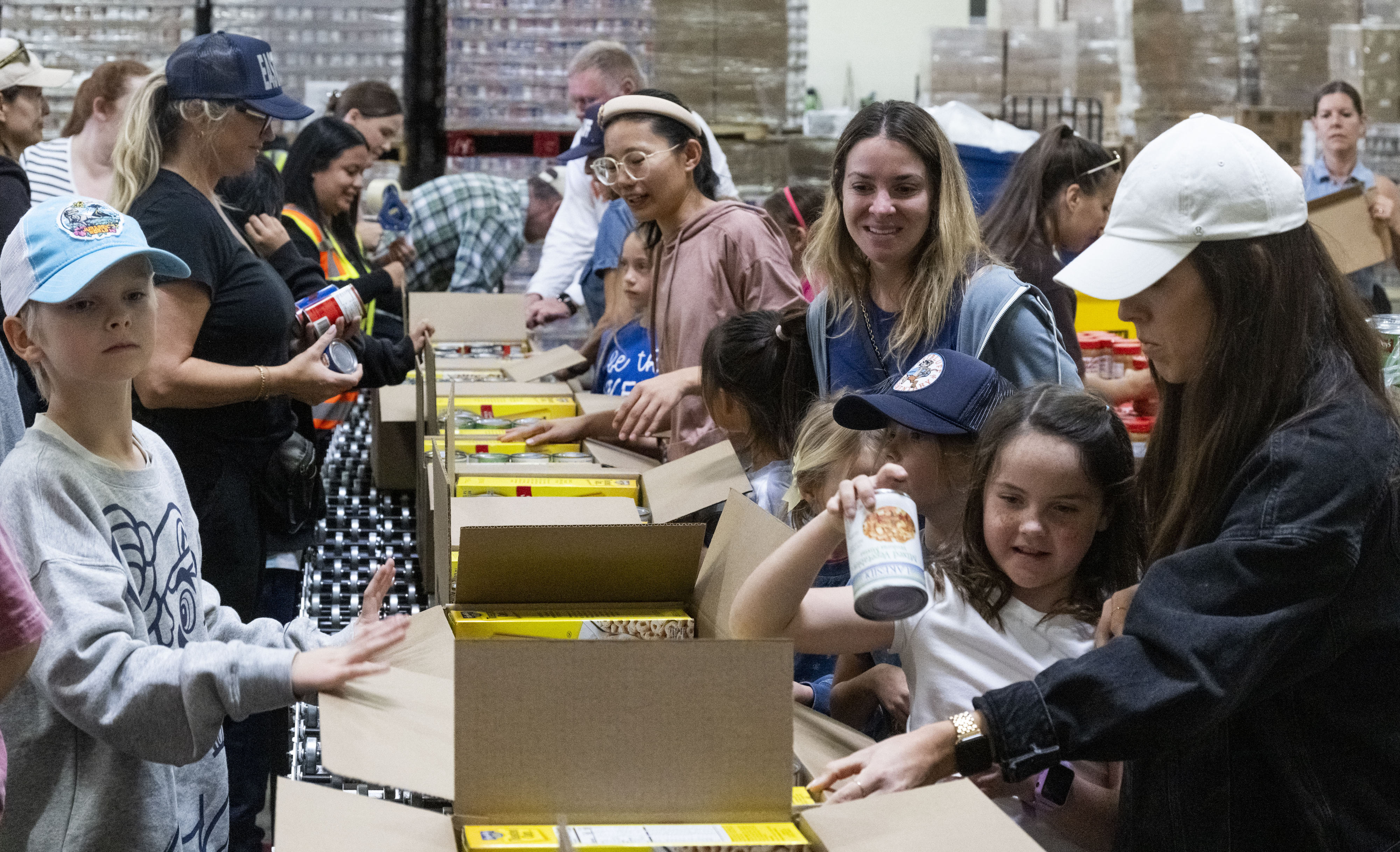 Volunteers pack boxes of shelf-stable food during the Martin Luther...