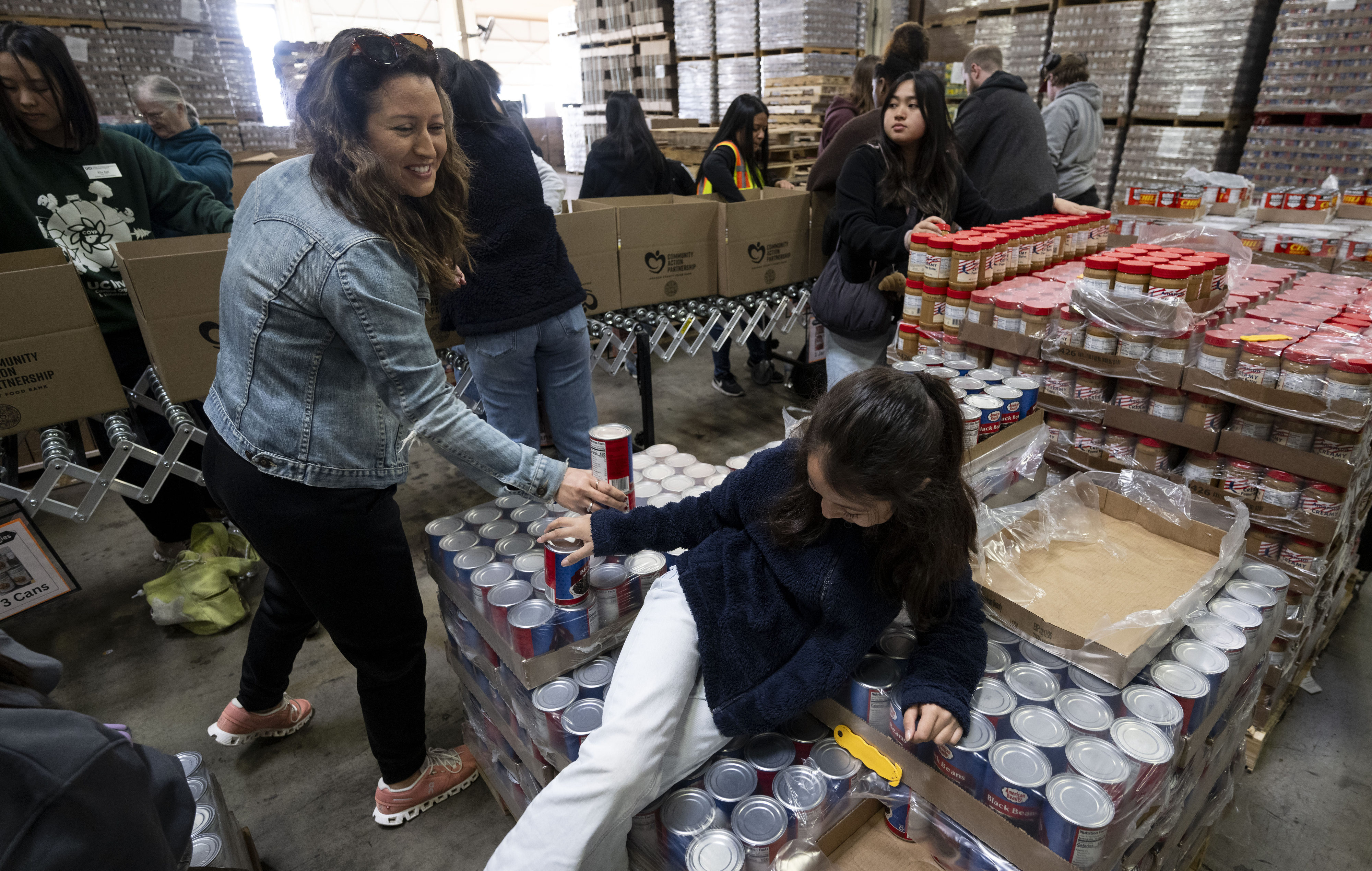 Maya Maldonado hands canned goods to her mom Adeli during...