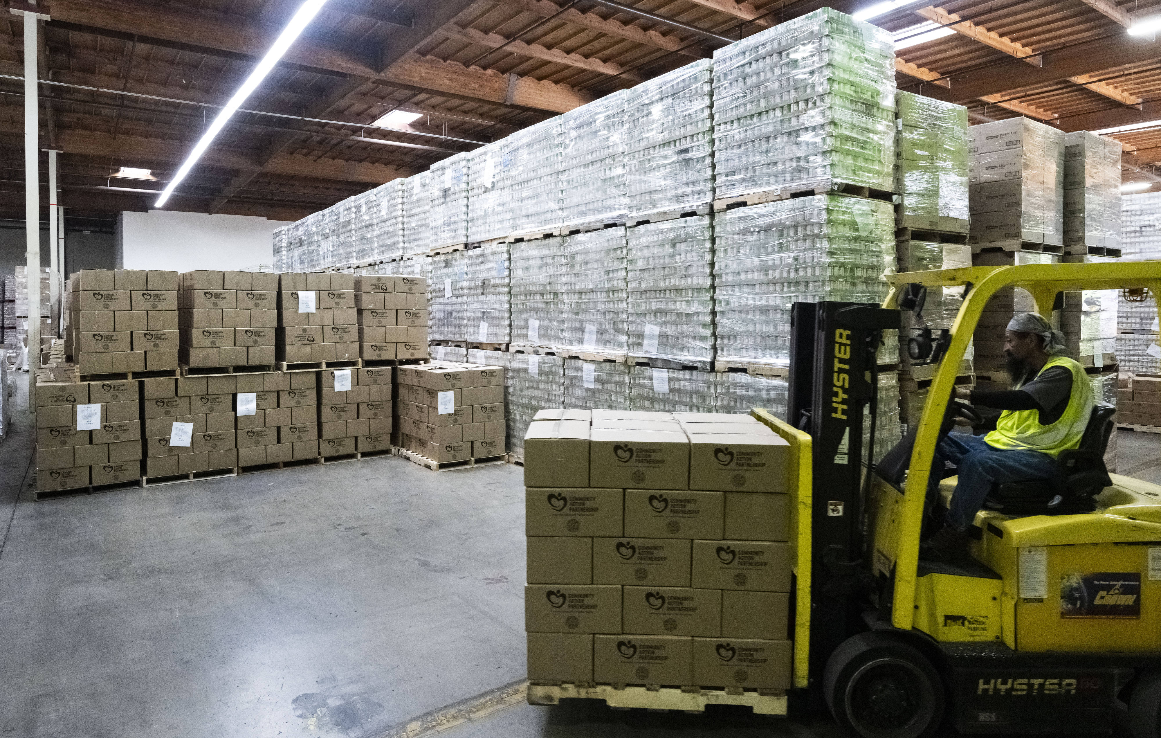Workers move boxes of shelf-stable food during the Martin Luther...
