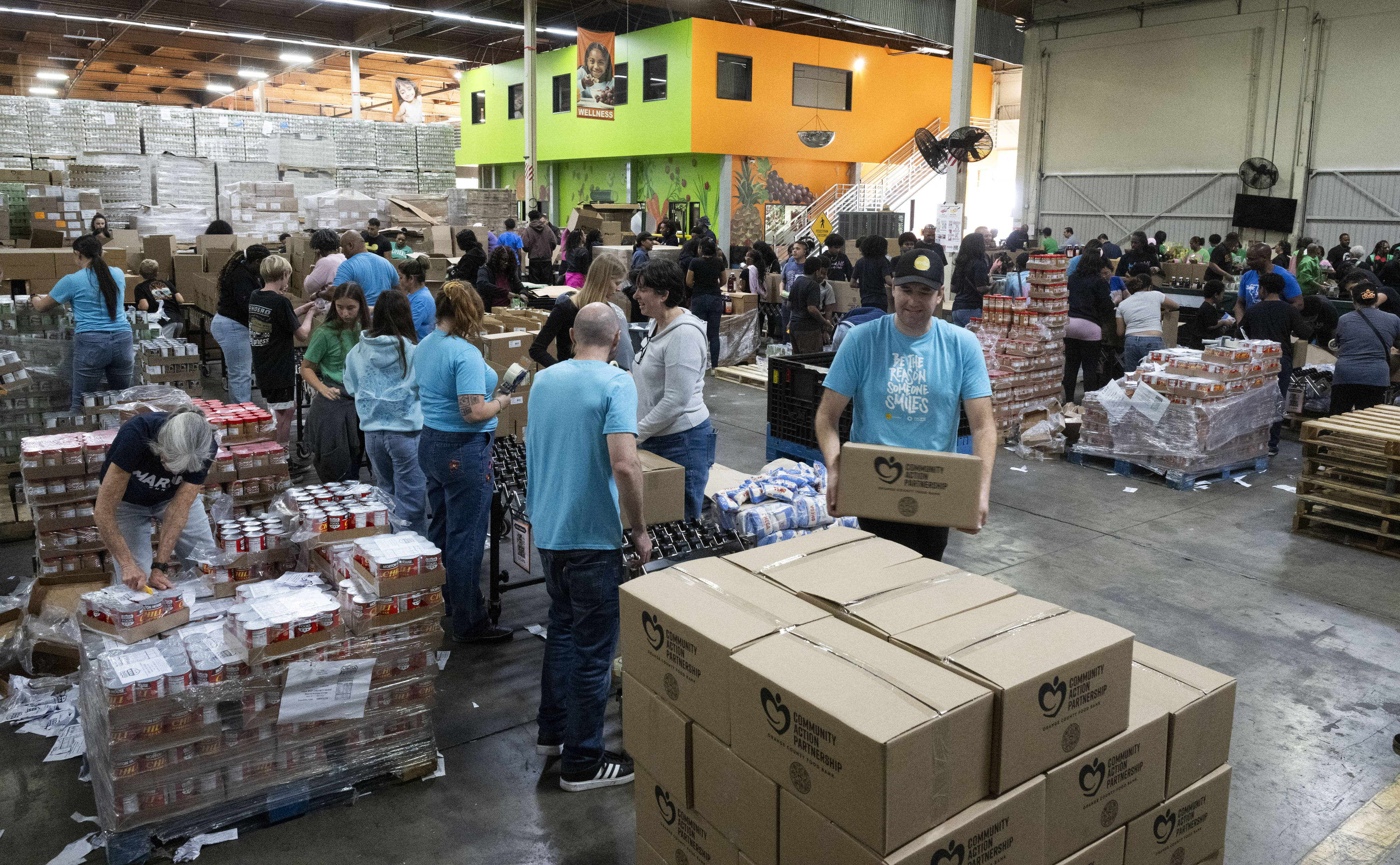 Volunteers pack boxes of shelf-stable food during the Martin Luther...