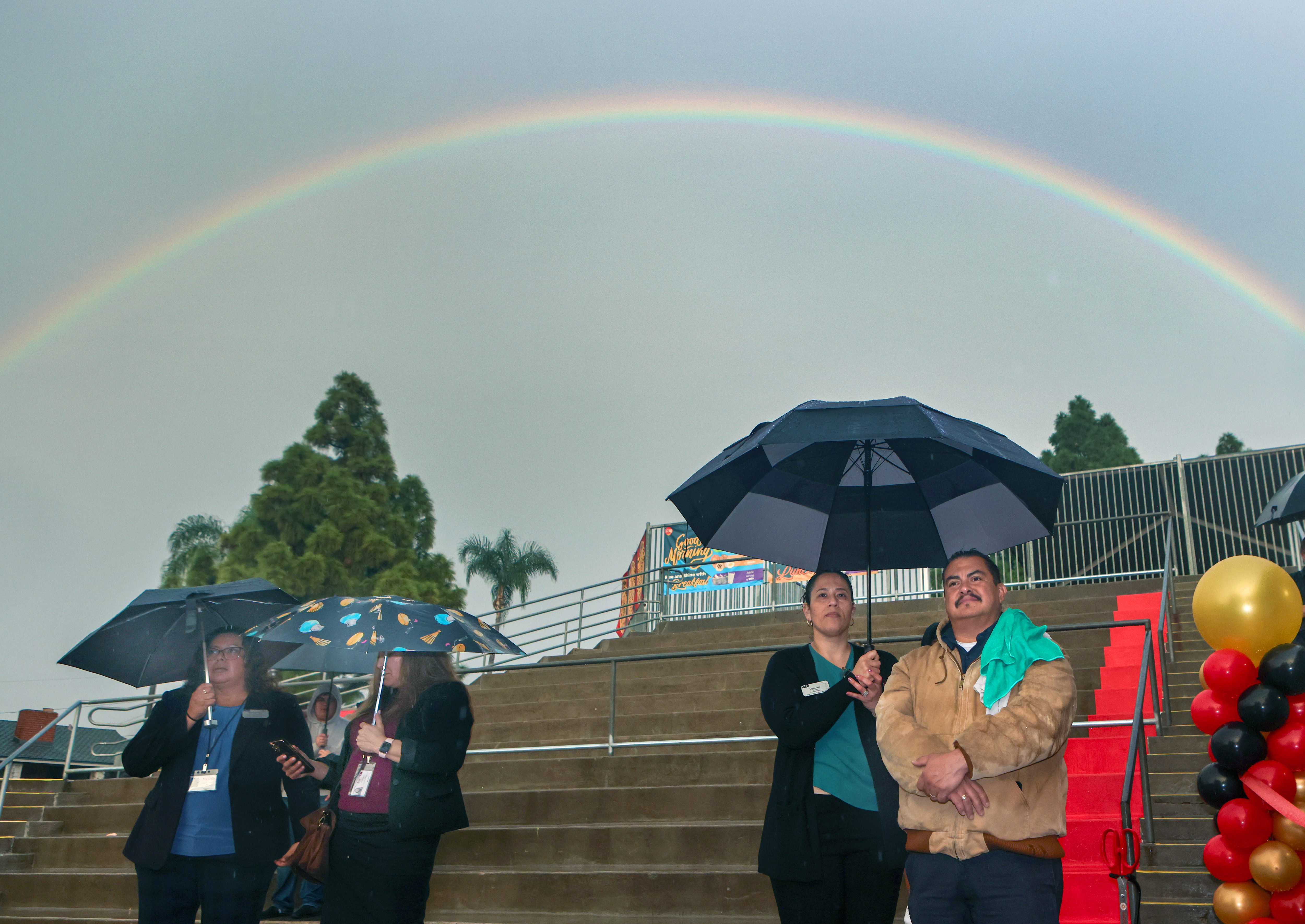 A rainbow appears as Maricela Roque, far left, Dianna Torres,...