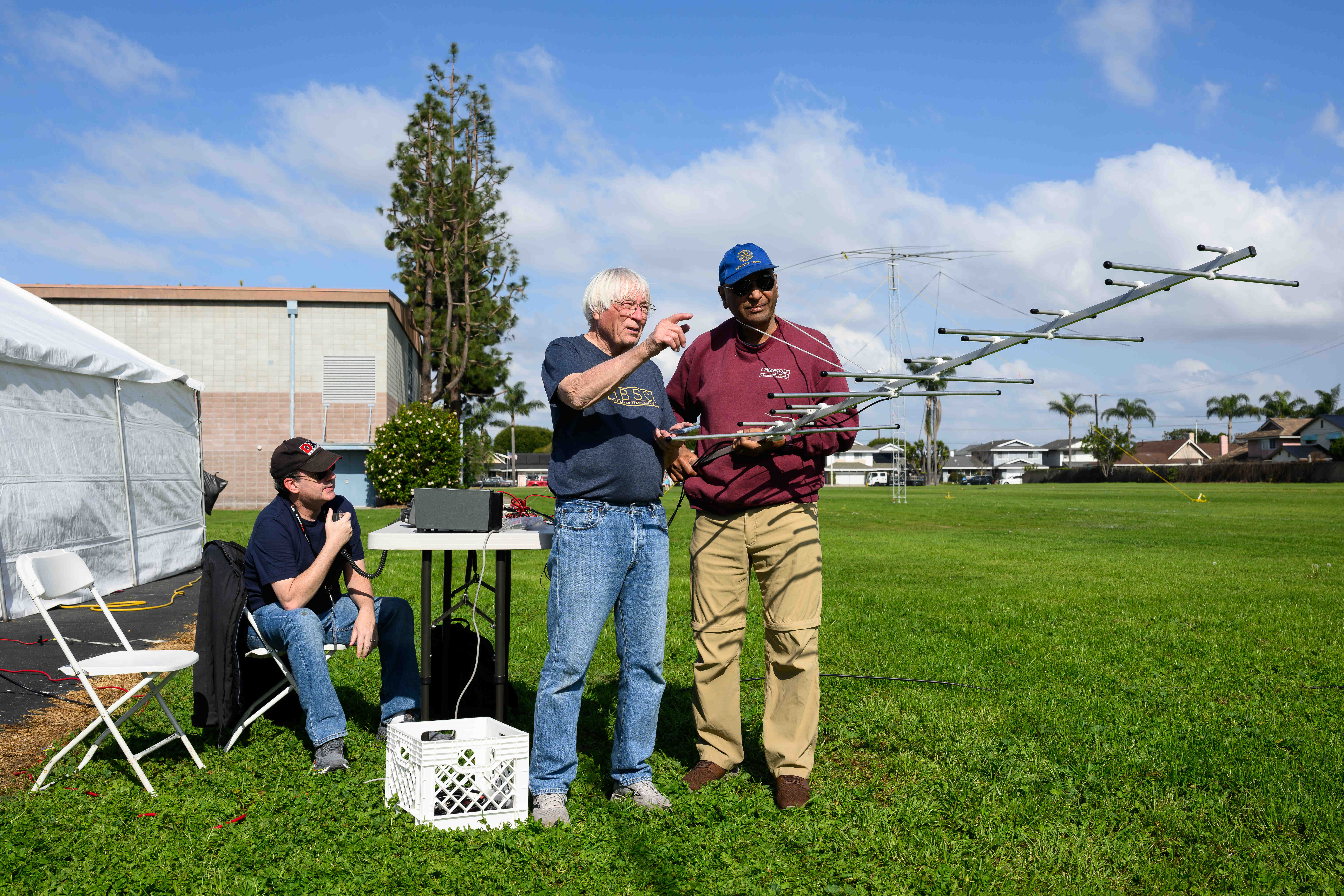 Ron Mudry, center, and Vijay Anand, right, aim an antenna...