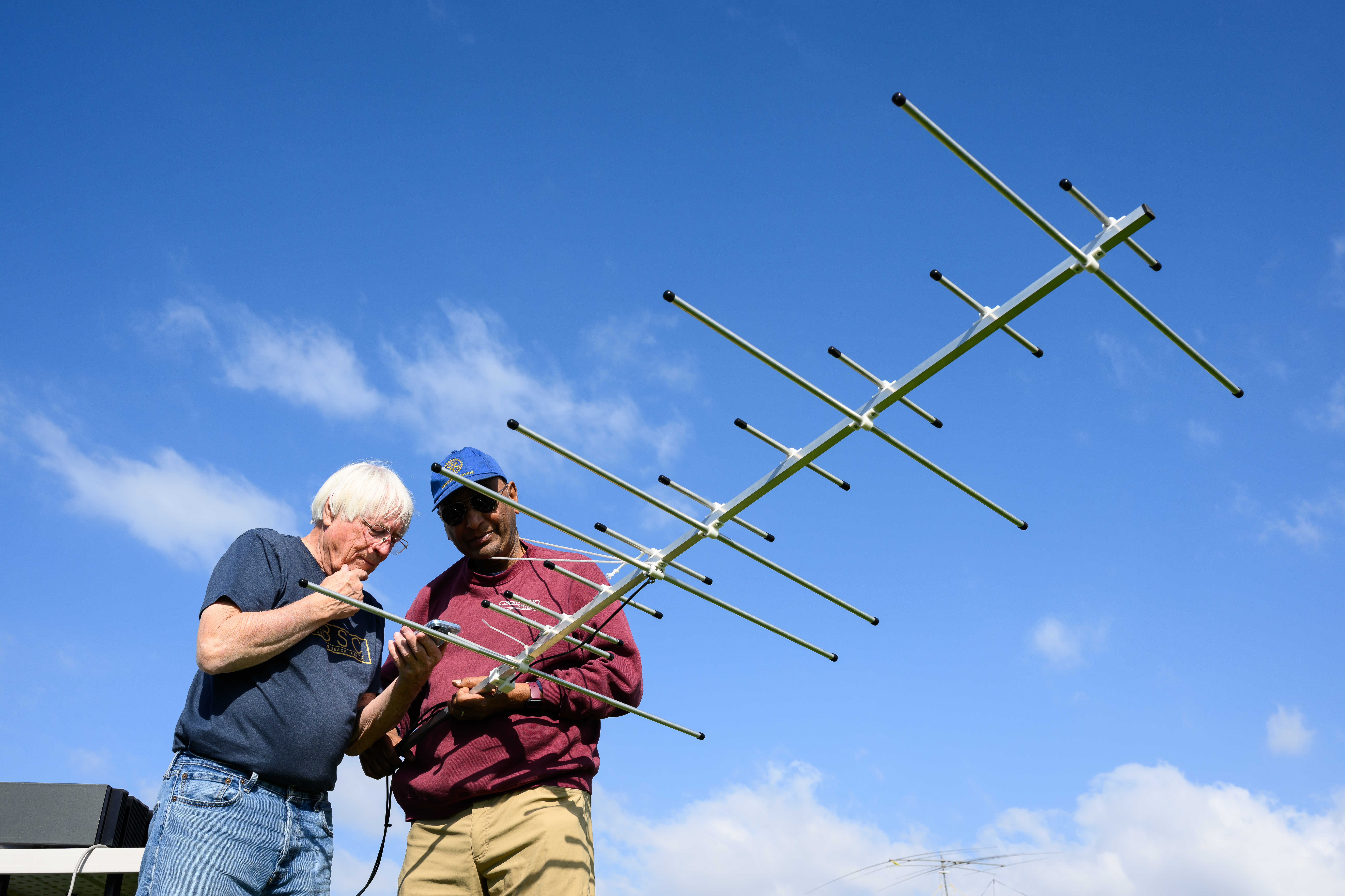 Ron Mudry, left, and Vijay Anand aim an antenna to...