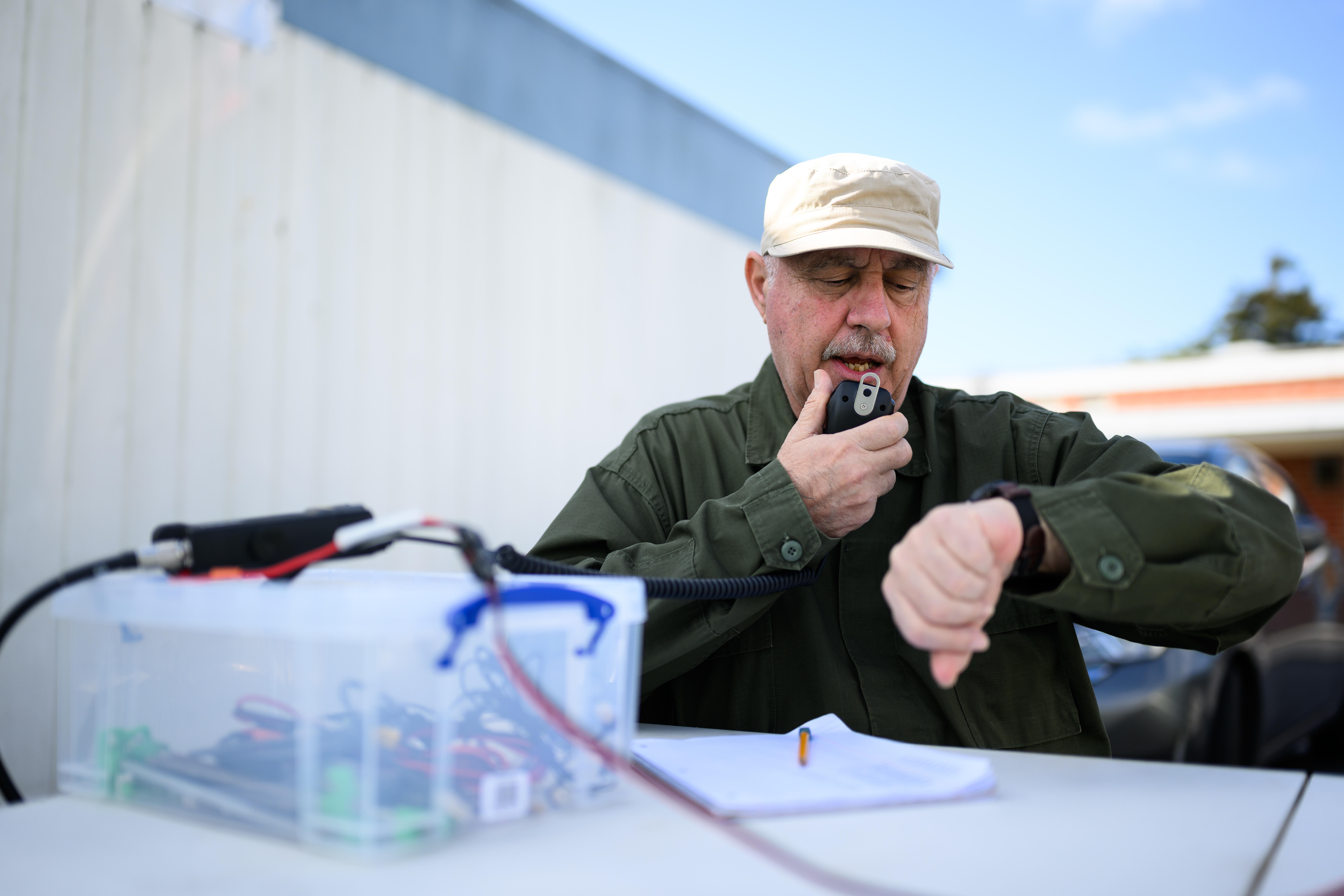 Harold Valenzuela speaks with another radio operator for the Orange...