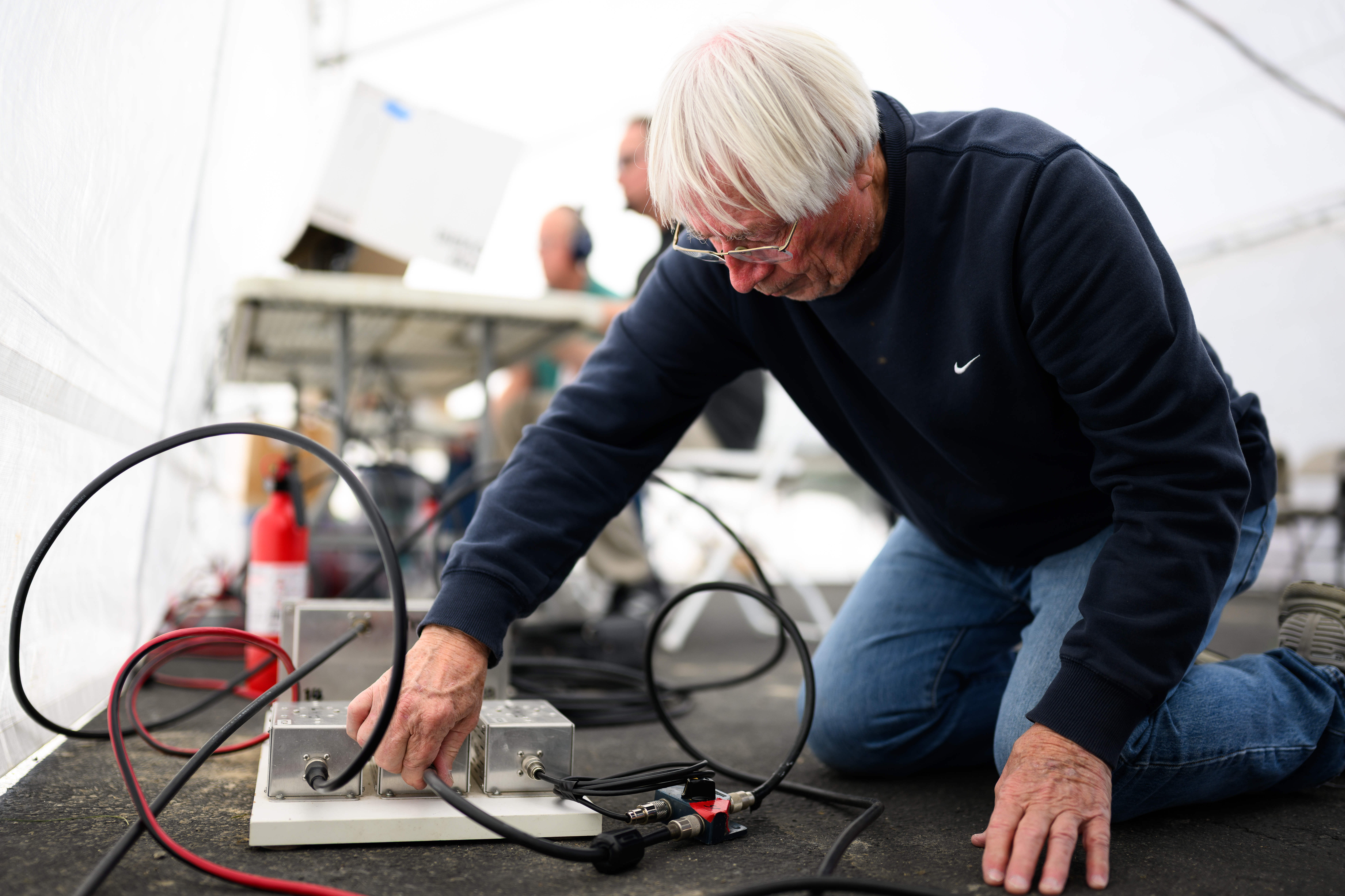 Ron Mudry makes adjustments to a radio for the Orange...