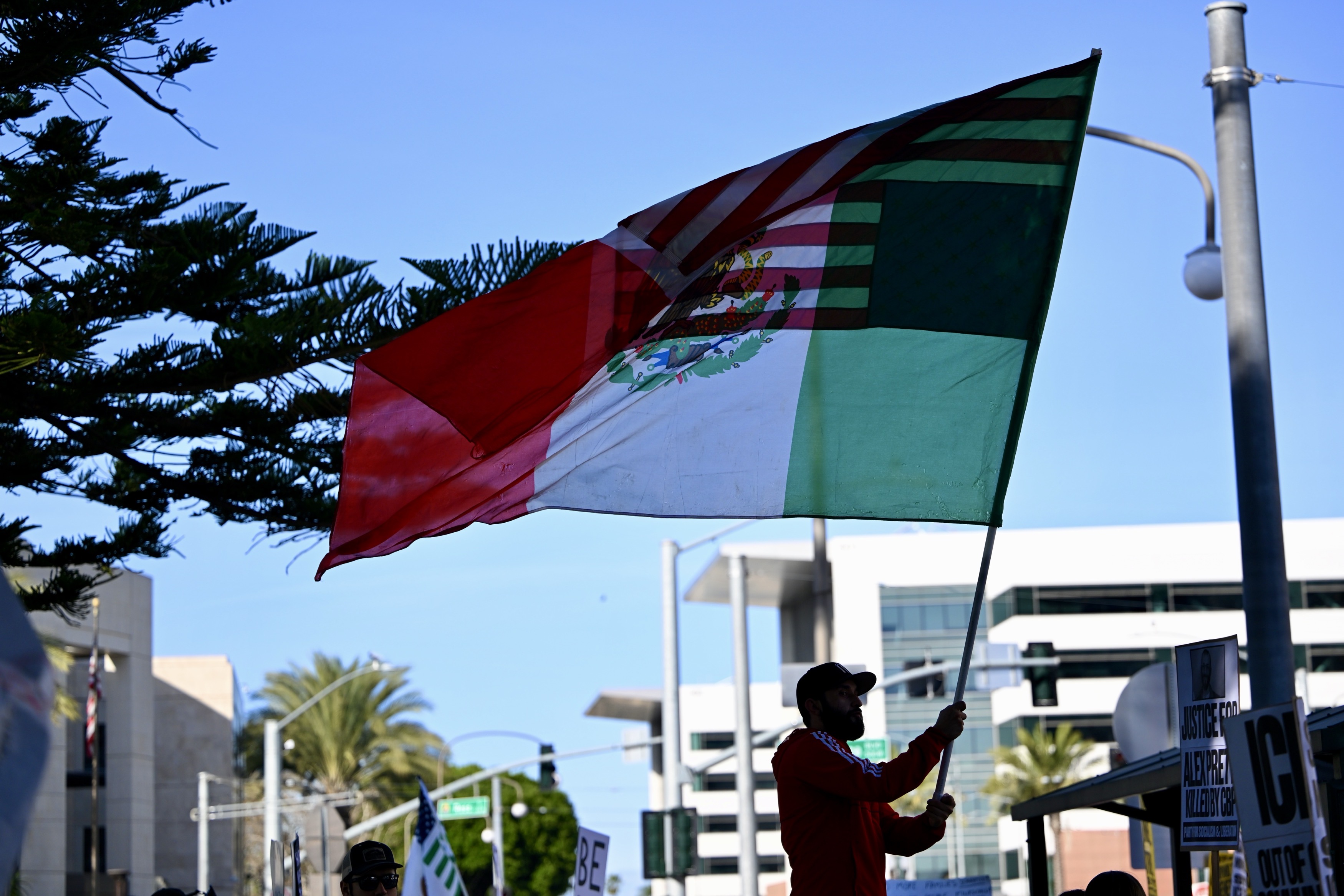 Junior Medina waves a giant flag during a demonstration against...