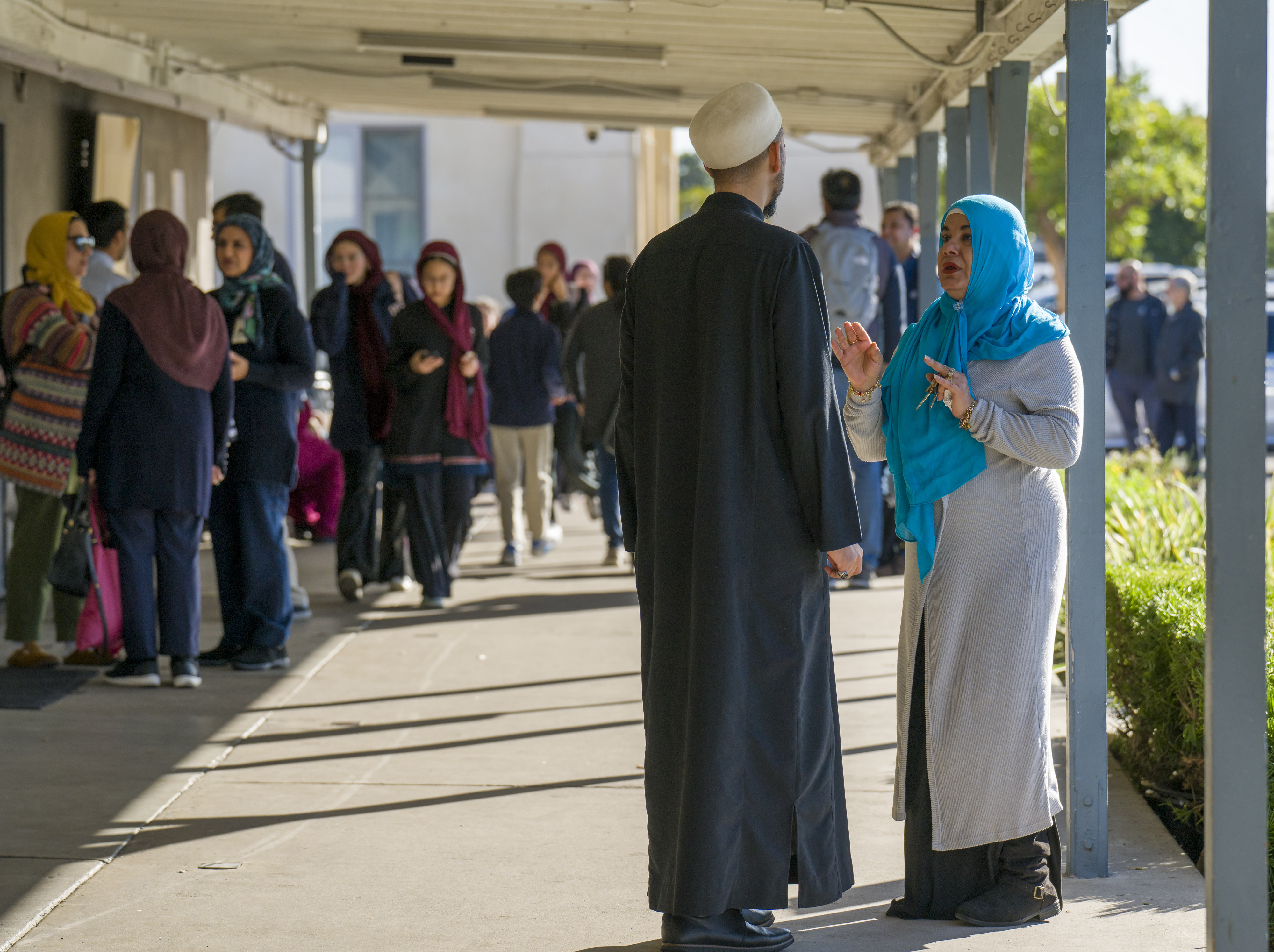 People gather under the breezeway to visit after prayer at...