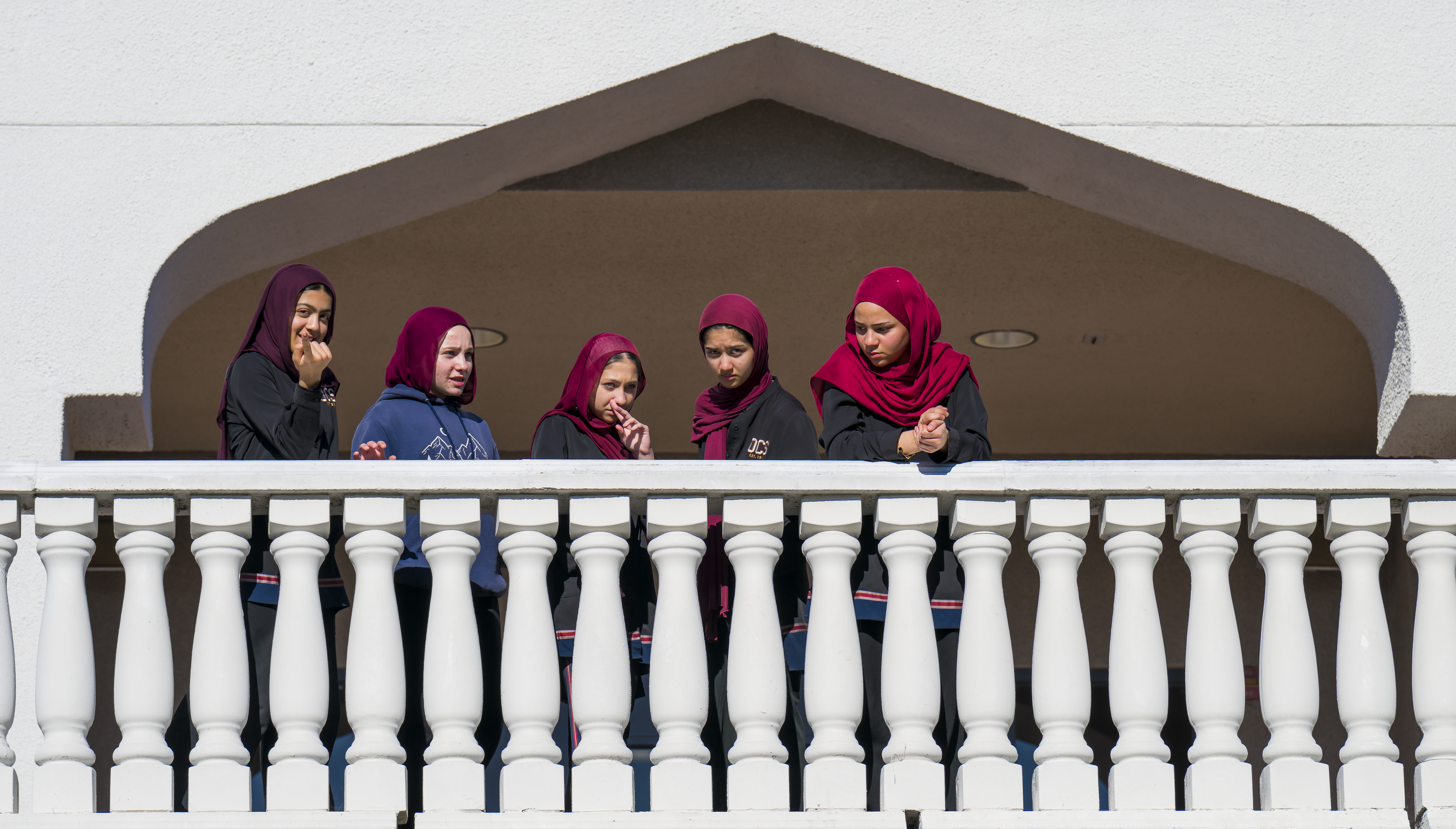 Teenage girls come out to the second-story patio after prayer...
