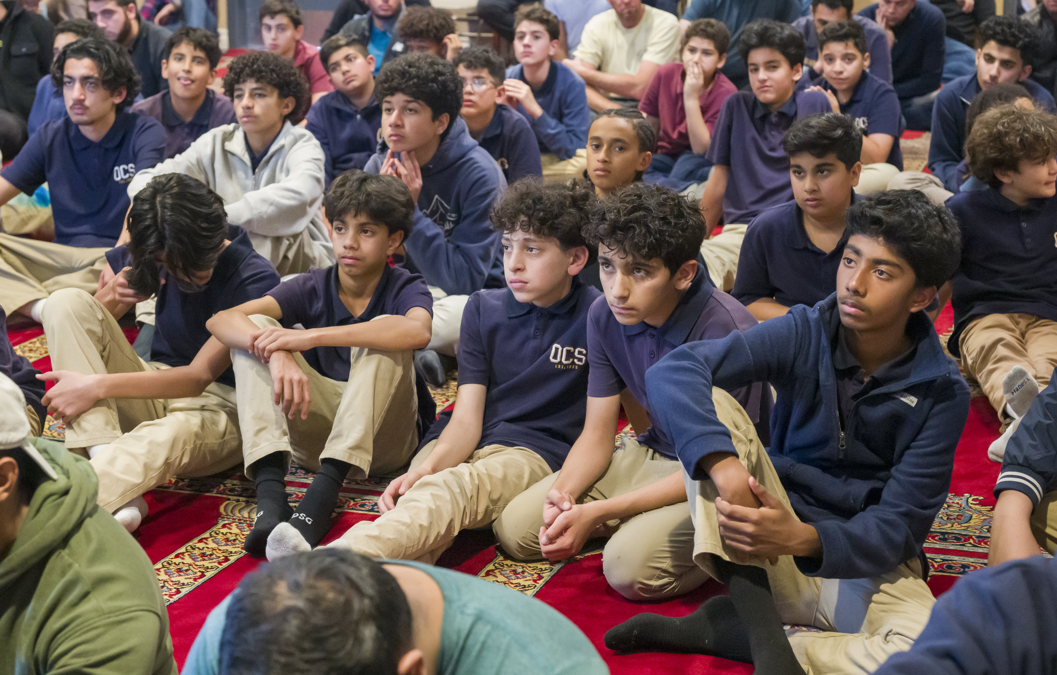 Teenage boys listen to a sermon by Imam Fayaz Nawabi...
