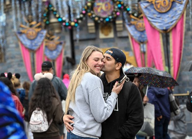 Aaron Banaga kisses his wife, Kelly Banaga, in front of Sleeping Beauty Castle inside Disneyland Park at the Disneyland Resort on Friday, November 14, 2025, in Anaheim, CA. (Photo by Jeff Gritchen, Orange County Register/SCNG)
