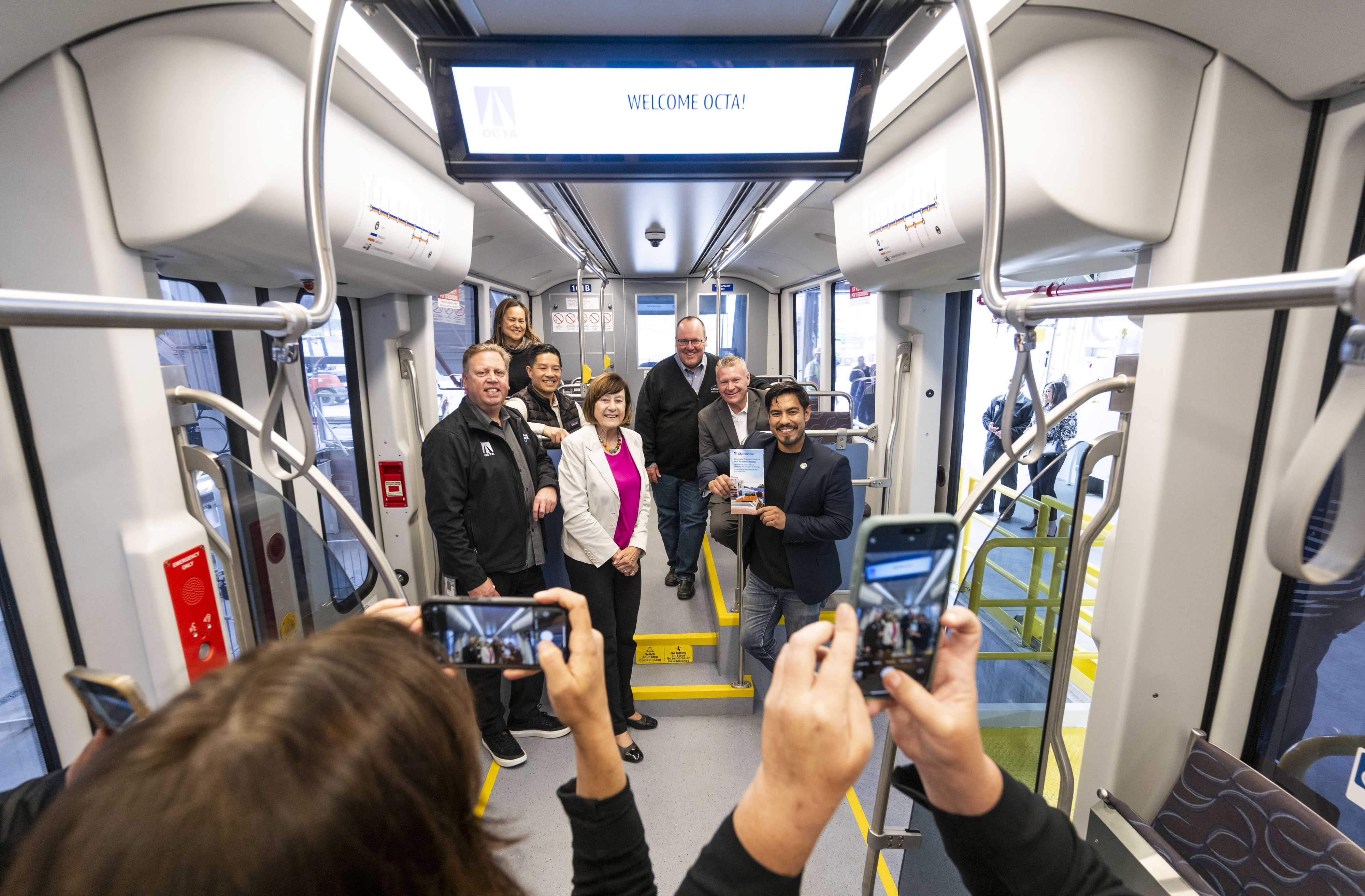 Officials take a photo while touring the first streetcar at...
