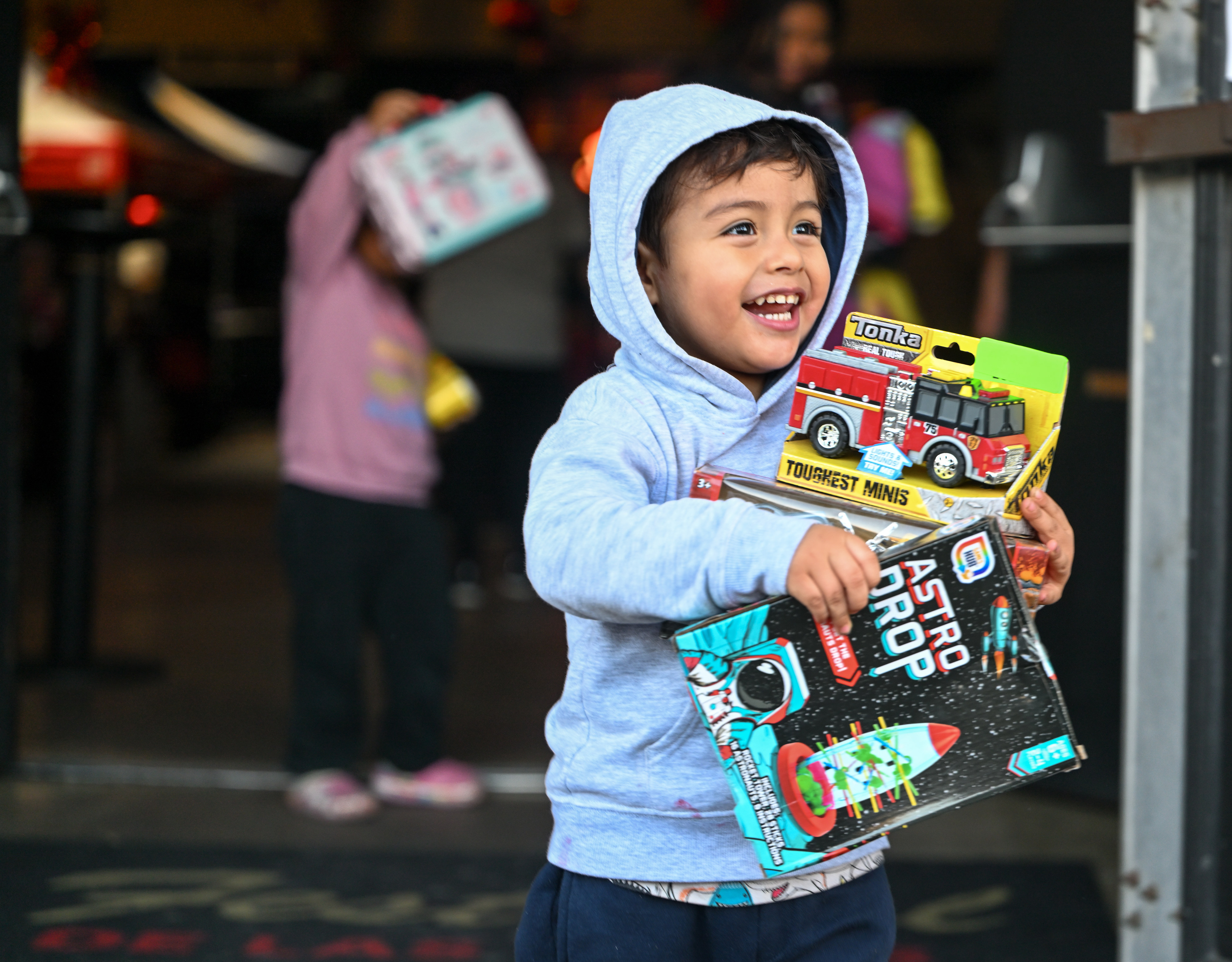 Liam Estuardo Mendez holds on to his toy haul as...