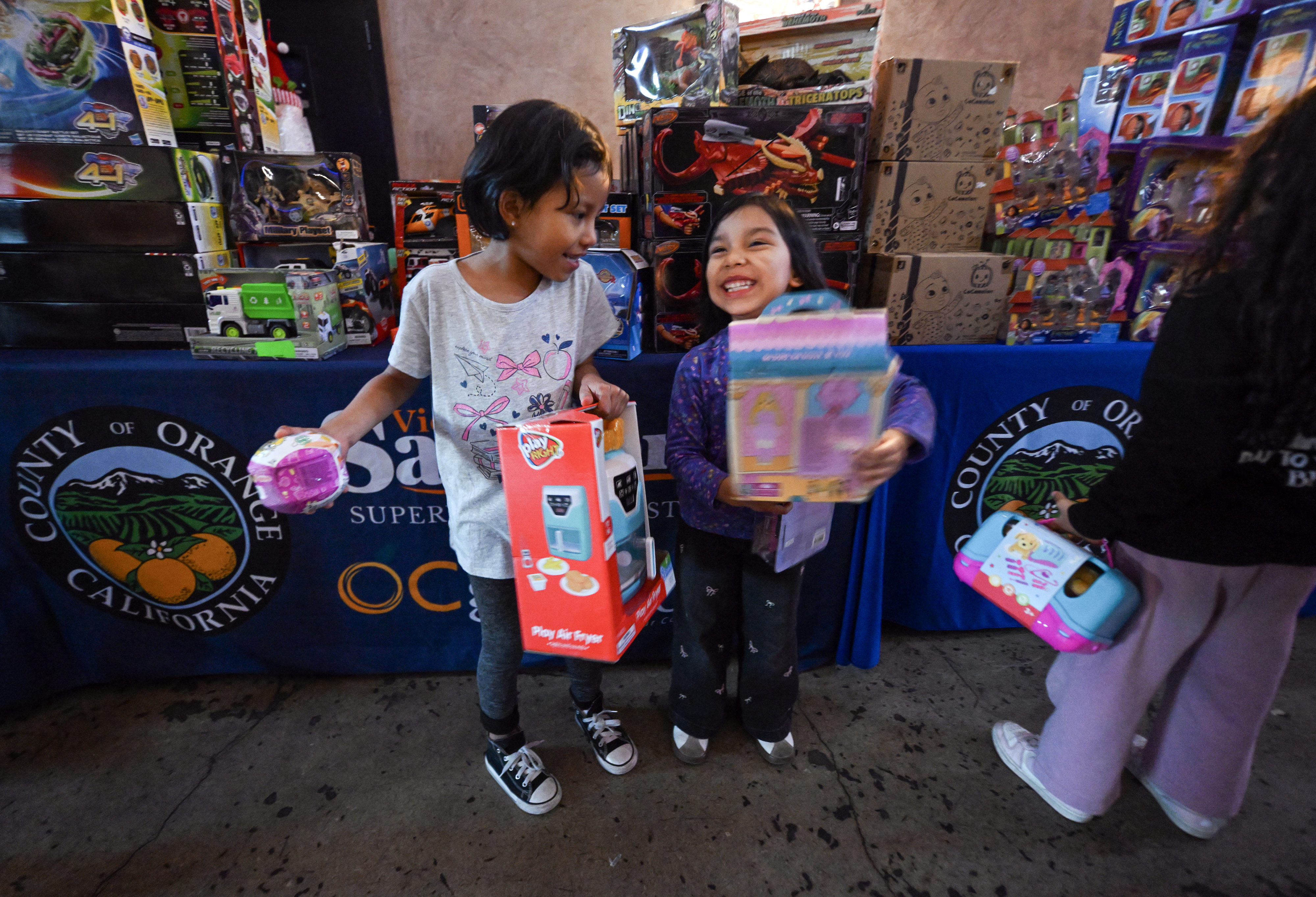 Mineidy (cq) Dominguez, 5, left, shares a laugh with her...