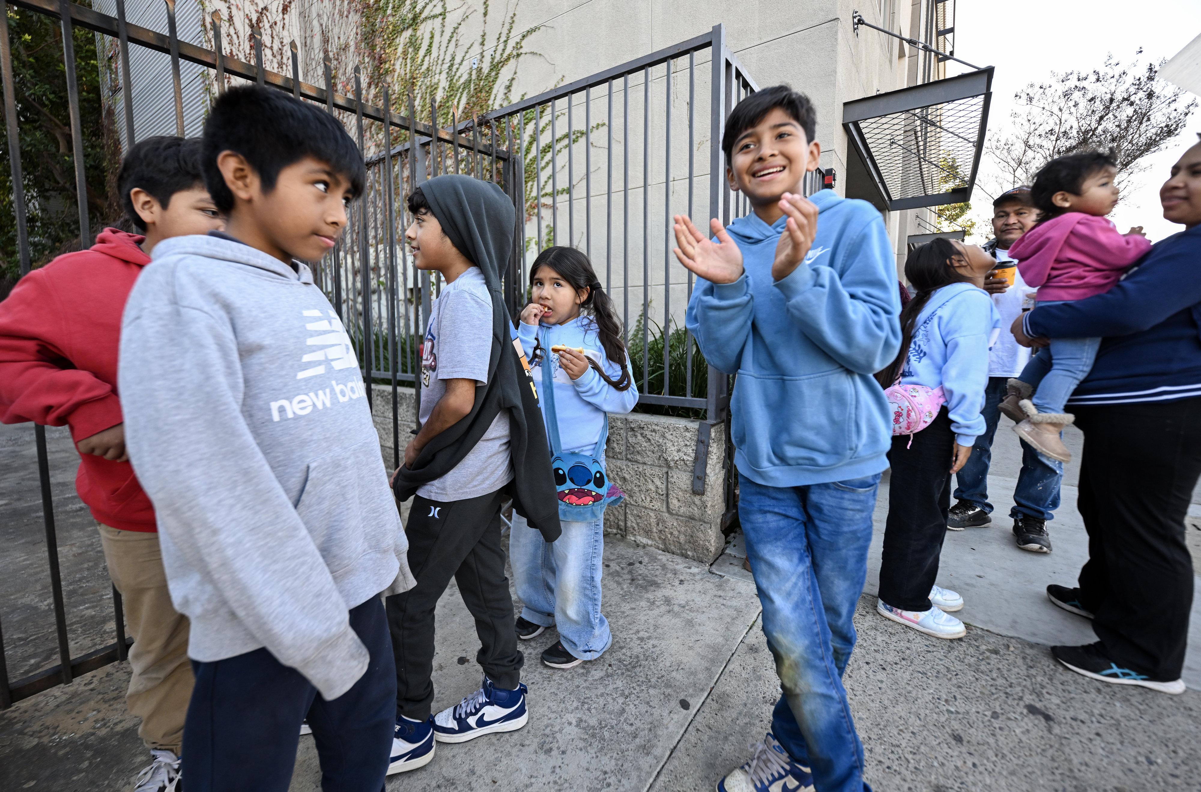 James Sandoval, right, chats with friends as he waits to...