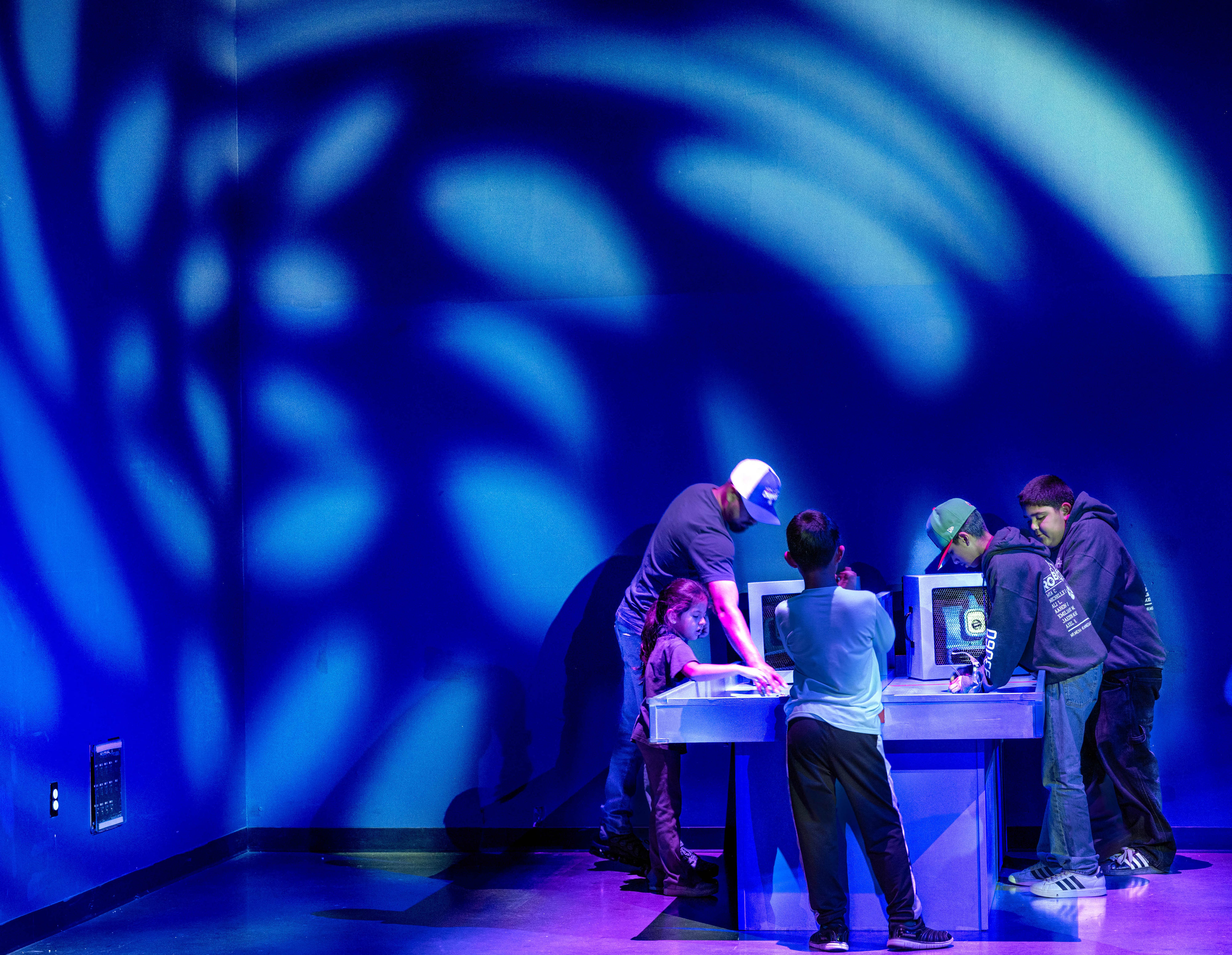 Children learn about wind at a hands-on table during Discovery...